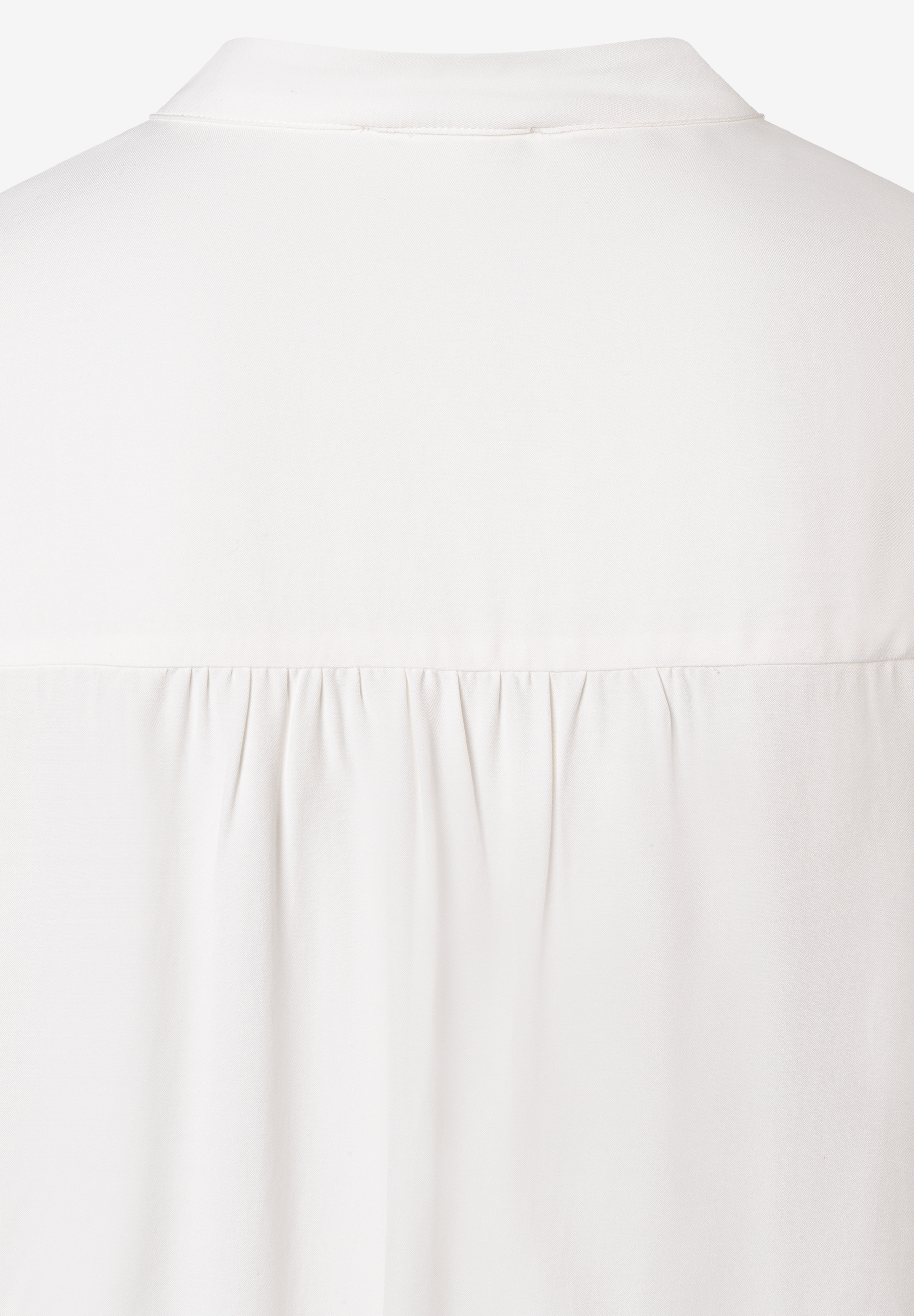Detailansicht einer weißen MORE & MORE Bluse aus fließender Viskose mit Kragen und Falten unterhalb der Rückenpasse. Detailansicht einer weißen MORE & MORE Bluse aus fließender Viskose mit Kragen und Falten unterhalb der Rückenpasse.
