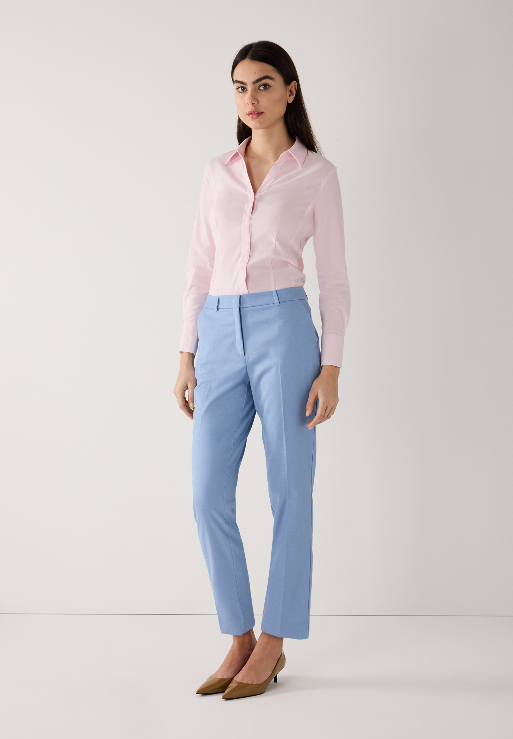 Eine Frau in MORE & MORE Baumwollmischung Bluse und blauen Hosen, vor einem weißen Hintergrund. Eine Frau in MORE & MORE Baumwollmischung Bluse und blauen Hosen, vor einem weißen Hintergrund.