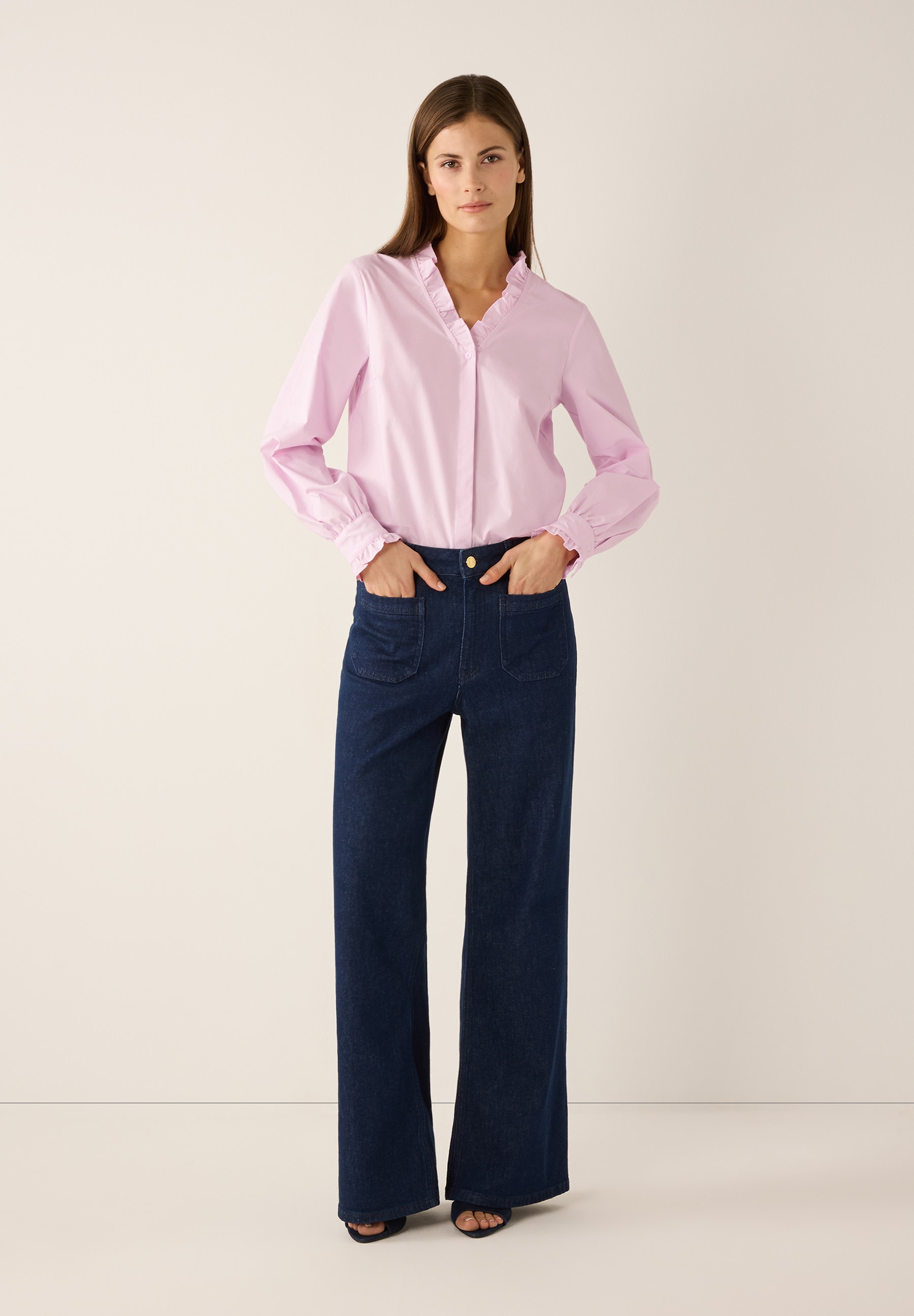 Eine Frau in MORE & MORE Bluse aus Popeline und Jeans mit Händen in den Taschen. Eine Frau in MORE & MORE Bluse aus Popeline und Jeans mit Händen in den Taschen.