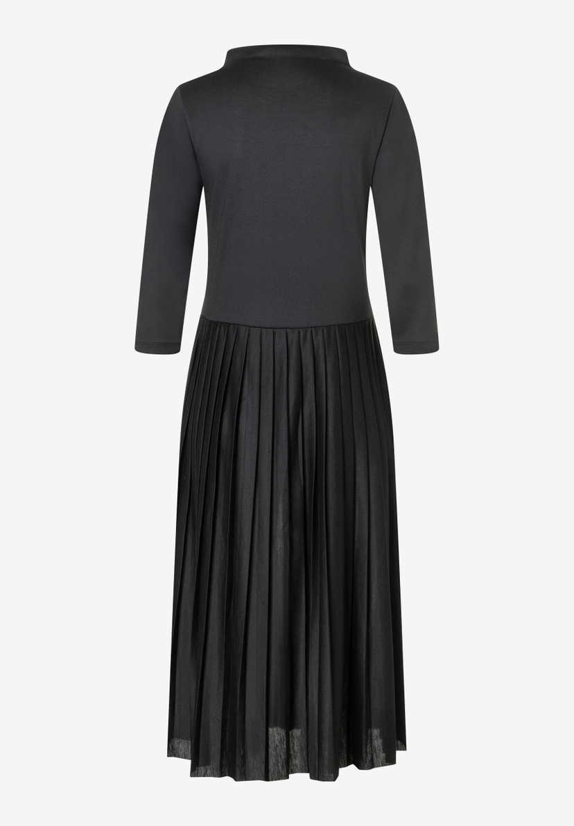 Ein schwarzes, knielanges Jersey-Kleid von MORE & MORE mit langen Ärmeln und einem plissierten Rockteil. Ein schwarzes, knielanges Jersey-Kleid von MORE & MORE mit langen Ärmeln und einem plissierten Rockteil.