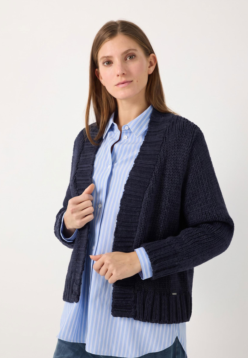 MORE & MORE Grobstrick-Cardigan, dunkelblau. Die Frau trägt einen blauen Cardigan mit einer blauen Bluse und Jeans. MORE & MORE Grobstrick-Cardigan, dunkelblau. Die Frau trägt einen blauen Cardigan mit einer blauen Bluse und Jeans.