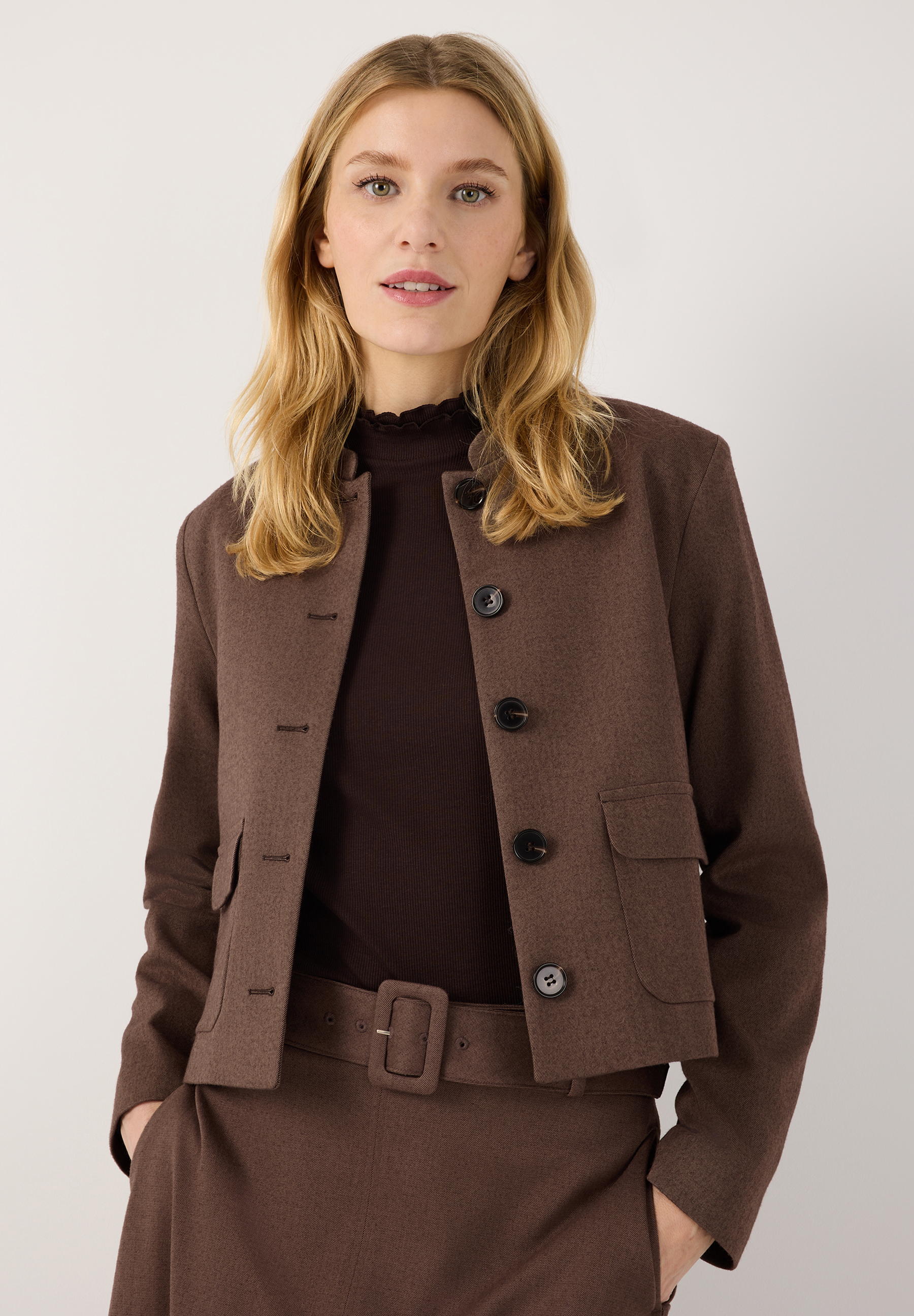 MORE & MORE Blazer in Dunkelbraun, kurz geschnitten. Das Model trägt den Blazer offen über einem Rollkragenpullover. MORE & MORE Blazer in Dunkelbraun, kurz geschnitten. Das Model trägt den Blazer offen über einem Rollkragenpullover.