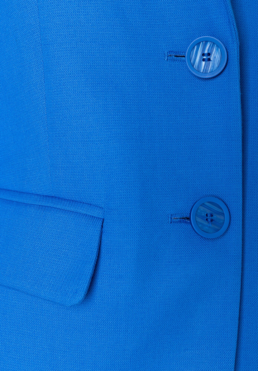 Nahaufnahme eines blauen MORE & MORE Blazers mit zwei Knöpfen und angedeuteter Tasche. Nahaufnahme eines blauen MORE & MORE Blazers mit zwei Knöpfen und angedeuteter Tasche.