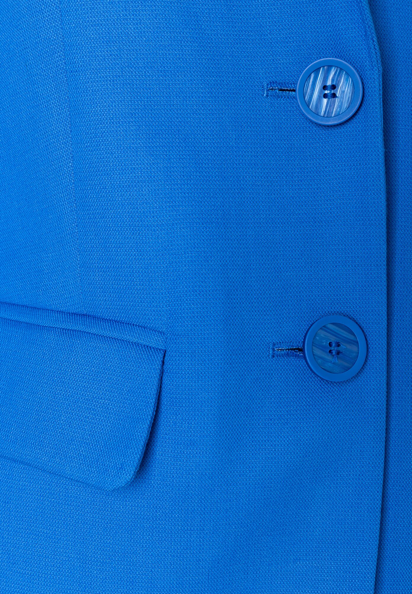 Nahaufnahme eines blauen MORE & MORE Blazers mit zwei Knöpfen und angedeuteter Tasche. Nahaufnahme eines blauen MORE & MORE Blazers mit zwei Knöpfen und angedeuteter Tasche.