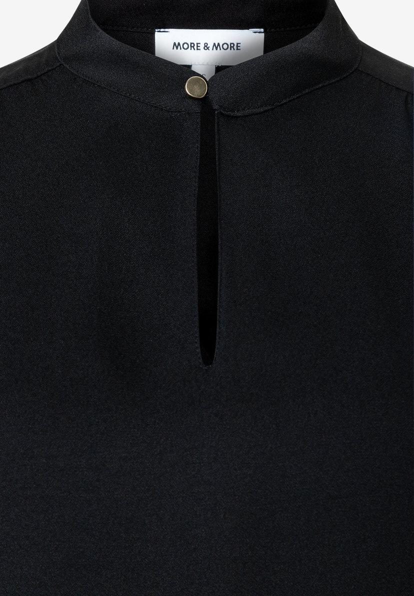 MORE & MORE schwarze Bluse mit Stehkragen und Schlüssellochausschnitt mit goldfarbenem Knopf auf weißem Hintergrund. MORE & MORE schwarze Bluse mit Stehkragen und Schlüssellochausschnitt mit goldfarbenem Knopf auf weißem Hintergrund.