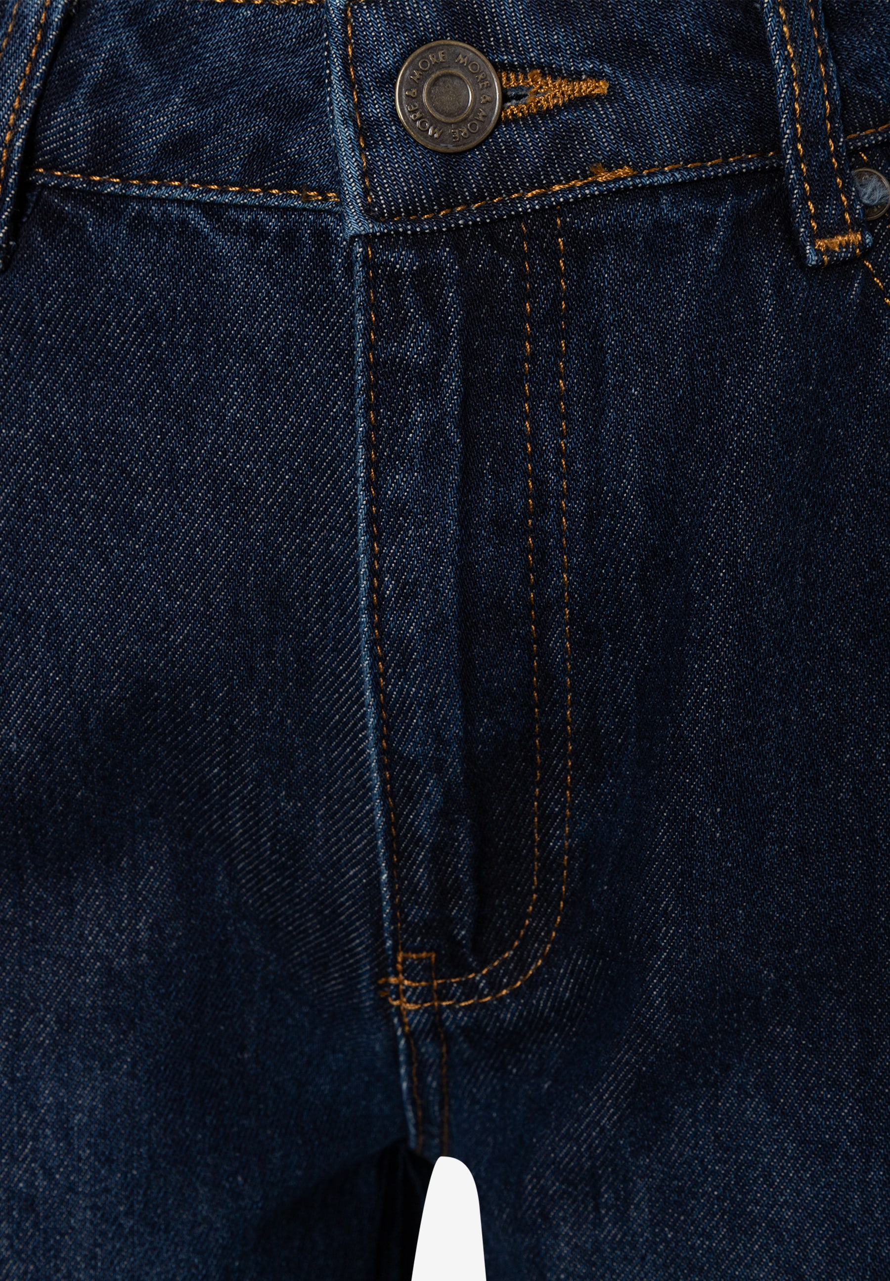 MORE & MORE Jeans: Nahaufnahme einer dunkelblauen Jeans mit goldener Naht und Knopfverschluss. MORE & MORE Jeans: Nahaufnahme einer dunkelblauen Jeans mit goldener Naht und Knopfverschluss.