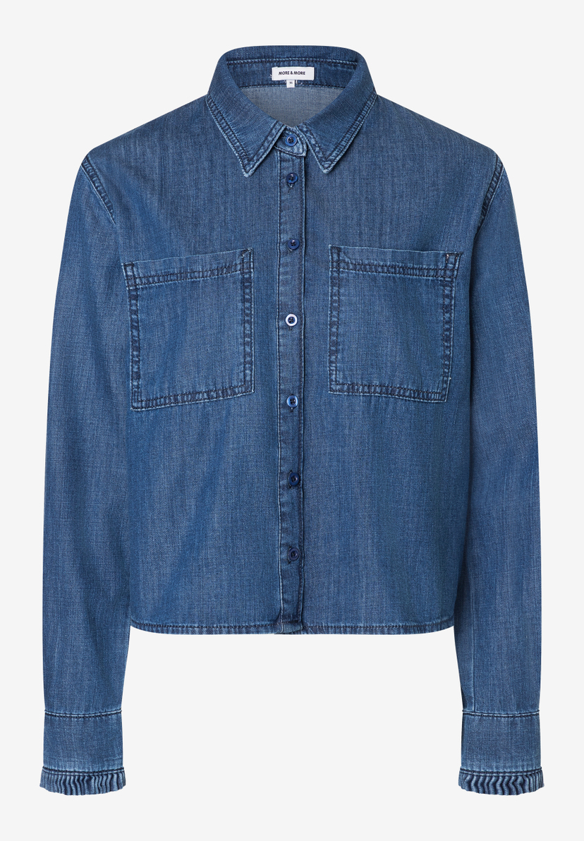 Eine MORE & MORE Damenbluse aus Denim mit Knopfleiste und zwei Brusttaschen. Eine MORE & MORE Damenbluse aus Denim mit Knopfleiste und zwei Brusttaschen.