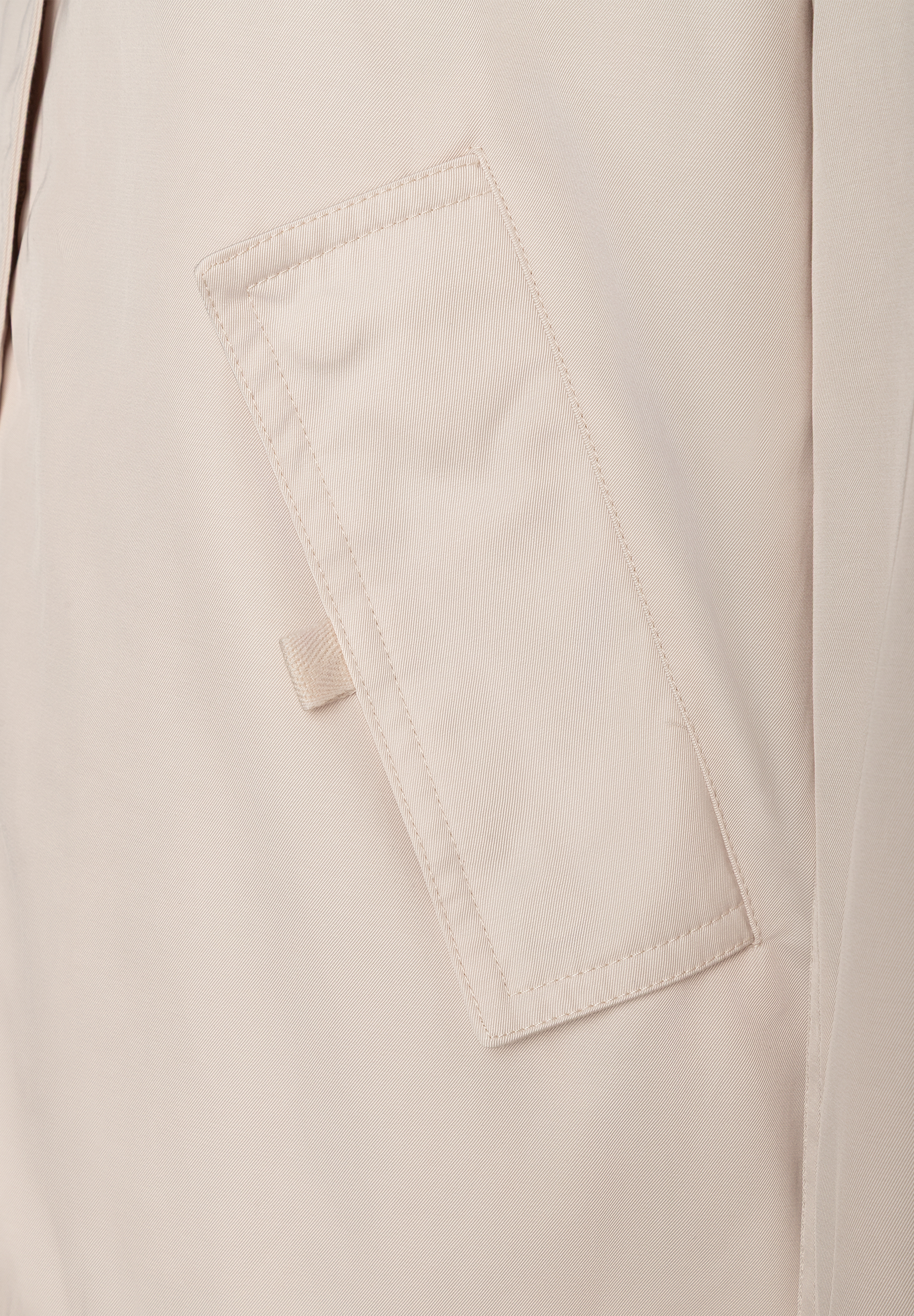 MORE & MORE Jacke: Nahaufnahme einer beigen Pattentasche mit kleinen Details und leichtem Glanz auf dem Stoff.