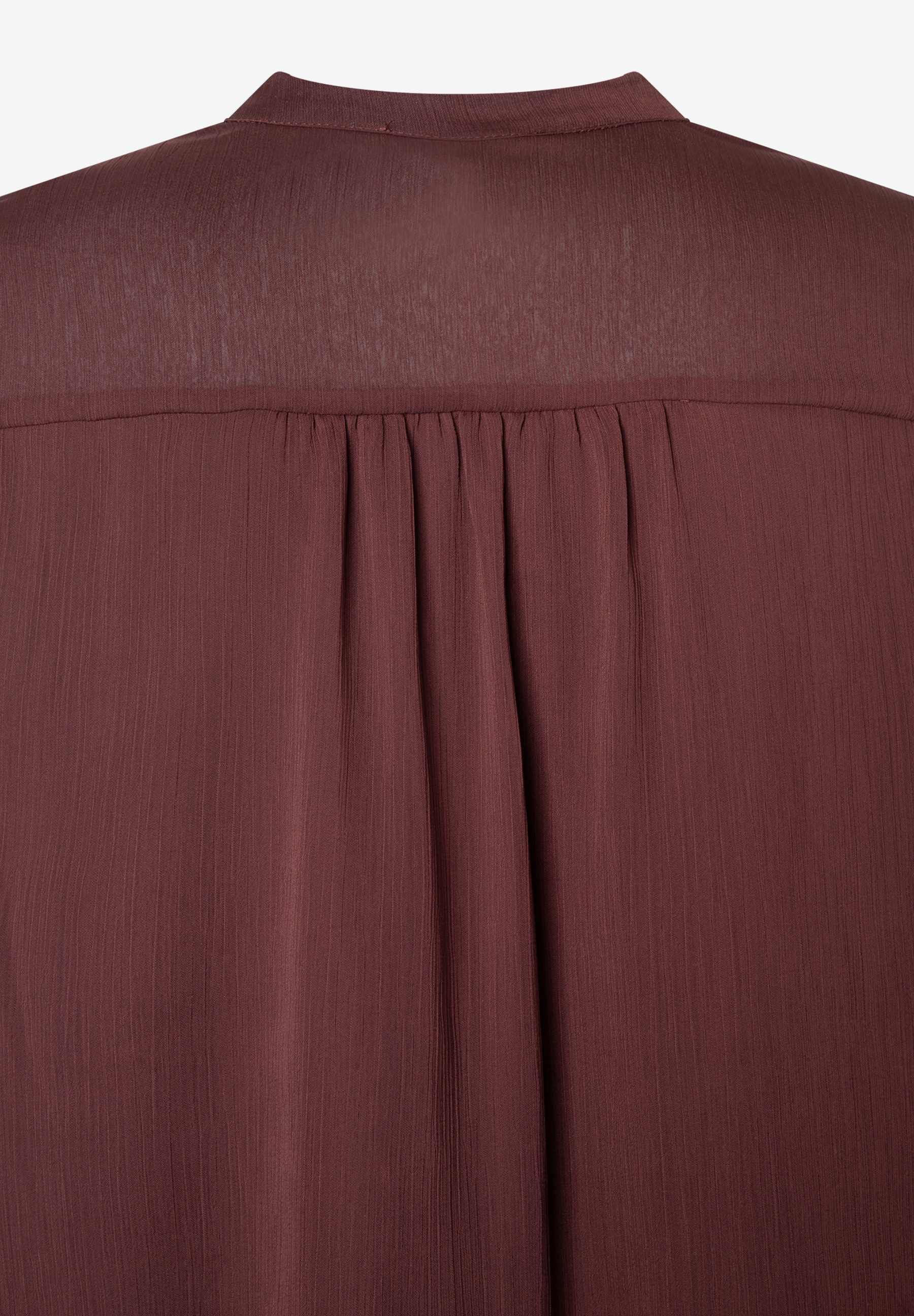 Nahaufnahme einer bordeauxroten MORE & MORE Bluse aus Chiffon mit leicht fließender Materialkonstruktion. Nahaufnahme einer bordeauxroten MORE & MORE Bluse aus Chiffon mit leicht fließender Materialkonstruktion.