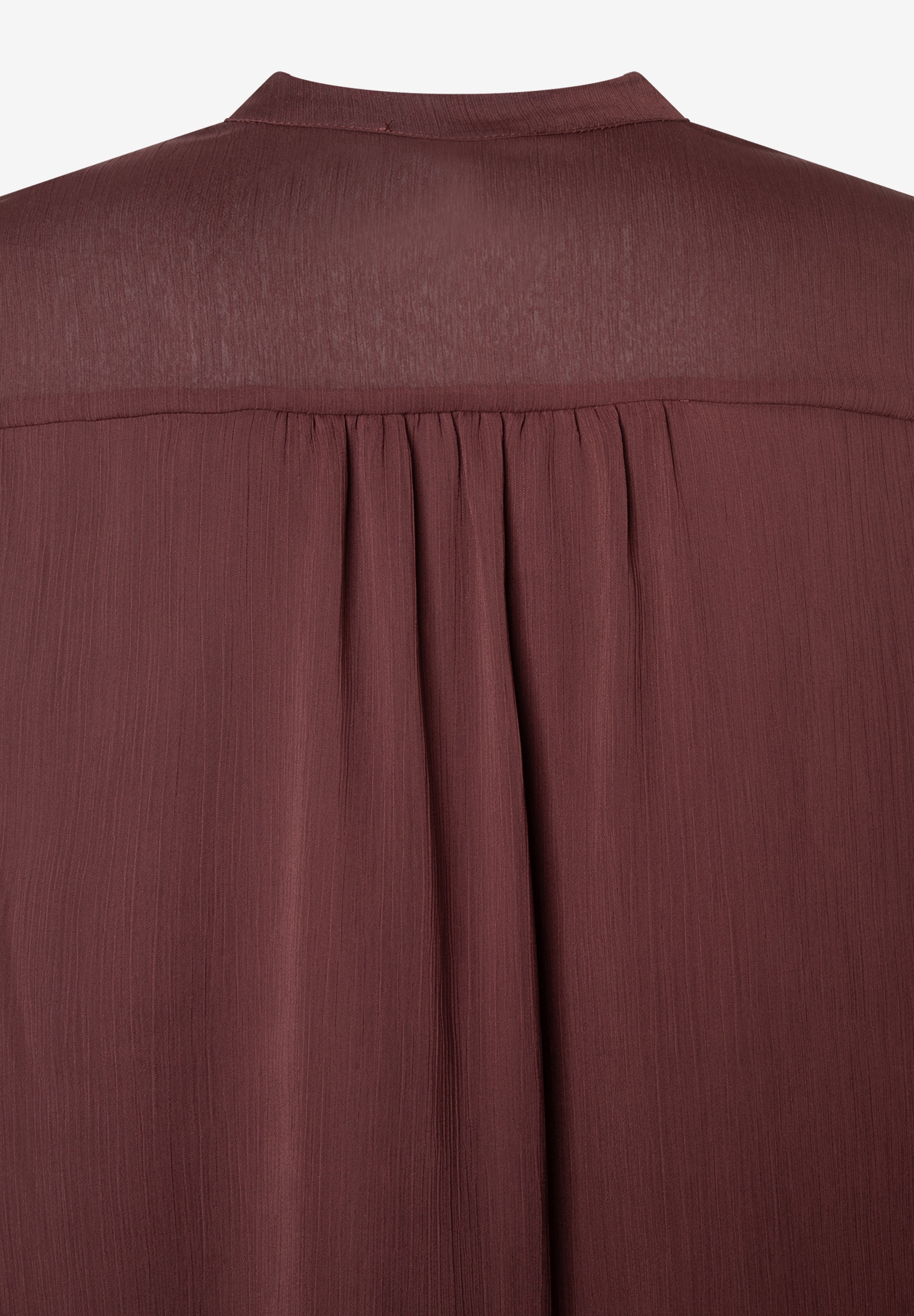Nahaufnahme einer bordeauxroten MORE & MORE Bluse aus Chiffon mit leicht fließender Materialkonstruktion. Nahaufnahme einer bordeauxroten MORE & MORE Bluse aus Chiffon mit leicht fließender Materialkonstruktion.