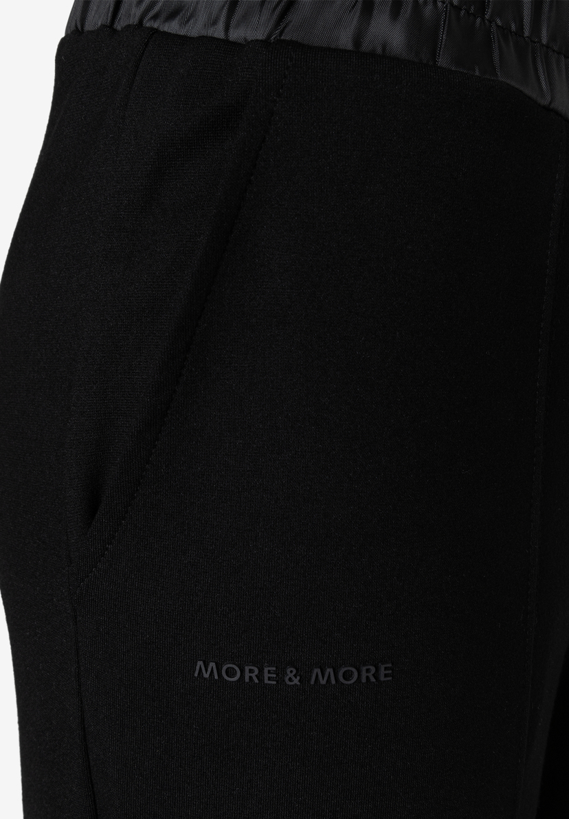 MORE & MORE schwarze Jersey-Jeans mit seitlichen Eingriffstaschen und glänzendem Bund. Logo-Schriftzug auf dem Oberschenkel. MORE & MORE schwarze Jersey-Jeans mit seitlichen Eingriffstaschen und glänzendem Bund. Logo-Schriftzug auf dem Oberschenkel.