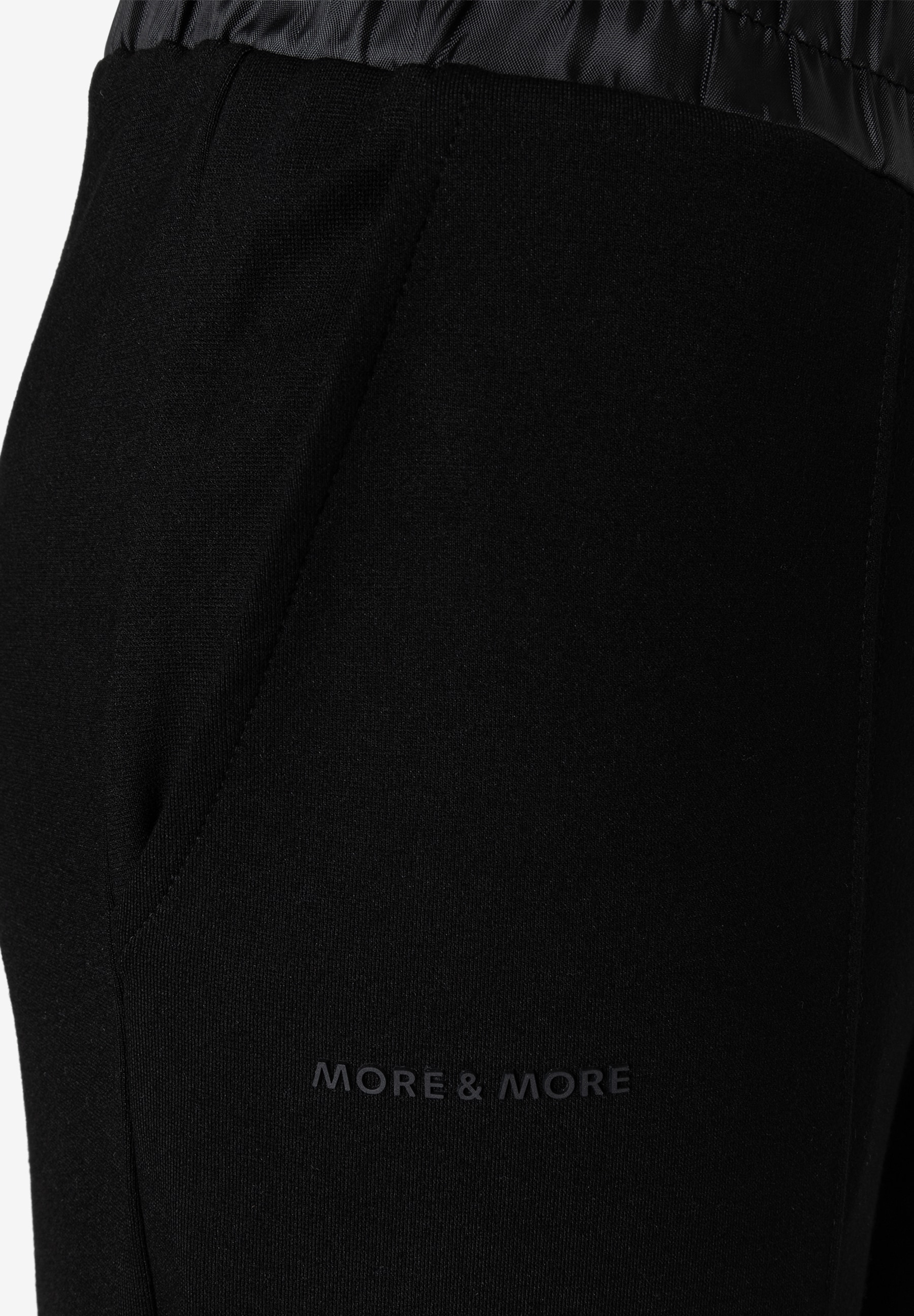 MORE & MORE schwarze Jersey-Jeans mit seitlichen Eingriffstaschen und glänzendem Bund. Logo-Schriftzug auf dem Oberschenkel. MORE & MORE schwarze Jersey-Jeans mit seitlichen Eingriffstaschen und glänzendem Bund. Logo-Schriftzug auf dem Oberschenkel.