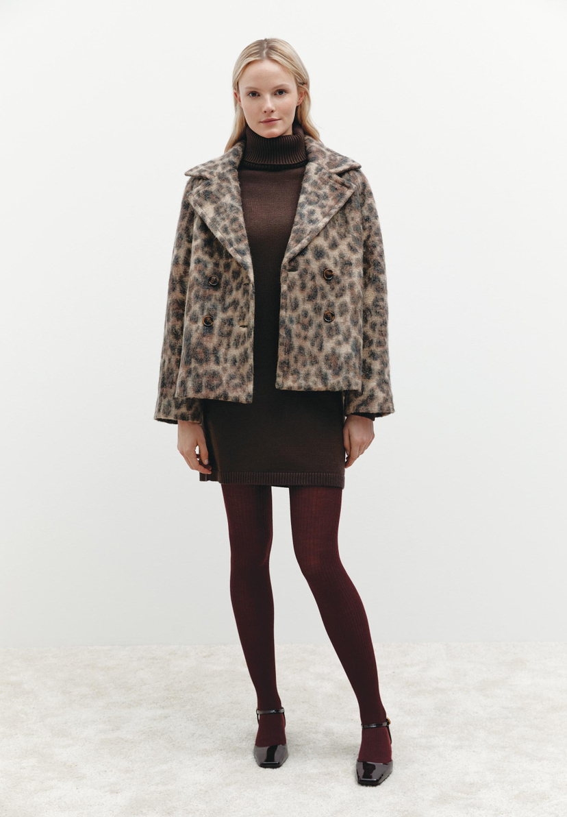 Eine Frau trägt ein MORE & MORE-Outfit mit Leopardenjacke, Rollkragenkleid und bordeauxroten Strumpfhosen. Eine Frau trägt ein MORE & MORE-Outfit mit Leopardenjacke, Rollkragenkleid und bordeauxroten Strumpfhosen.