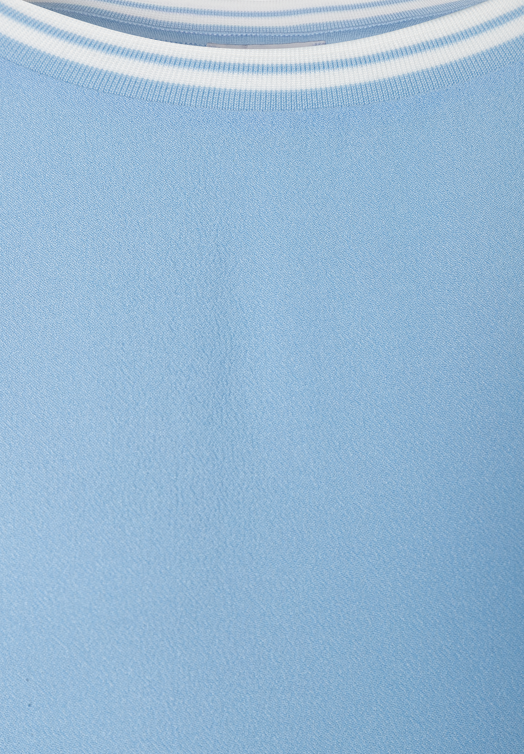 Nahaufnahme eines hellblauen MORE & MORE Oberteils mit weiß gestreiftem Halsausschnitt. Nahaufnahme eines hellblauen MORE & MORE Oberteils mit weiß gestreiftem Halsausschnitt.
