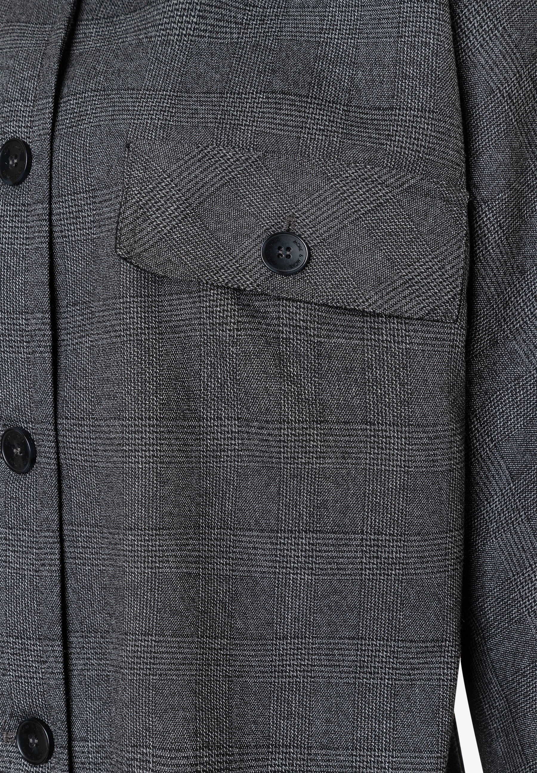 Nahaufnahme eines grauen MORE & MORE Blazers mit Karomuster, Brusttasche und Knöpfen. Nahaufnahme eines grauen MORE & MORE Blazers mit Karomuster, Brusttasche und Knöpfen.