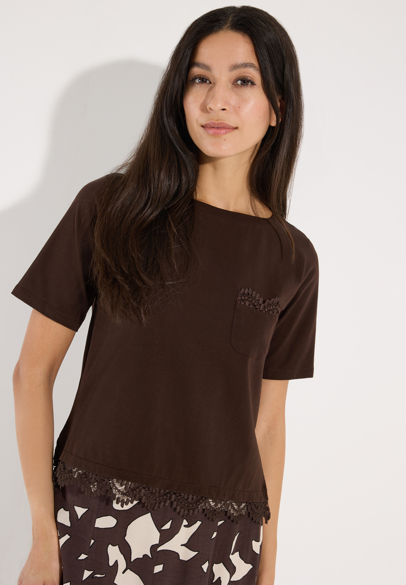 MORE & MORE T-Shirt in Braun, das eine junge Frau zeigt. Es hat kurze Ärmel, einen runden Halsausschnitt und eine verzierte Tasche. MORE & MORE T-Shirt in Braun, das eine junge Frau zeigt. Es hat kurze Ärmel, einen runden Halsausschnitt und eine verzierte Tasche.