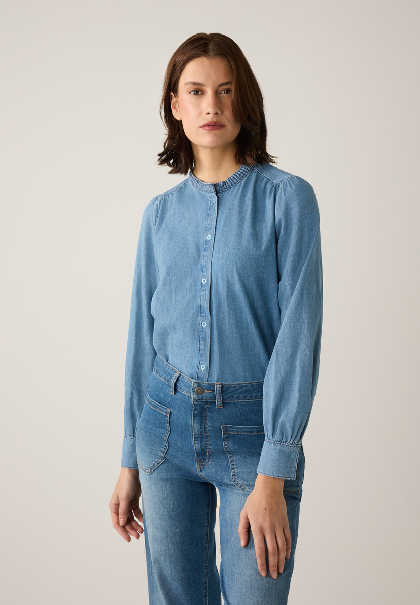 Eine Frau trägt ein Jeans-Ensemble von MORE & MORE, bestehend aus Bluse und Jeanshose. Eine Frau trägt ein Jeans-Ensemble von MORE & MORE, bestehend aus Bluse und Jeanshose.