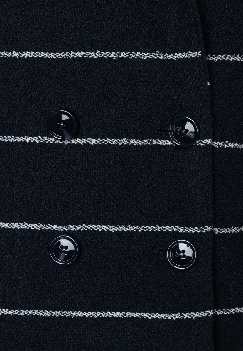 Detailansicht eines MORE & MORE Blazers mit Knöpfen und Bouclé-Streifen. Detailansicht eines MORE & MORE Blazers mit Knöpfen und Bouclé-Streifen.