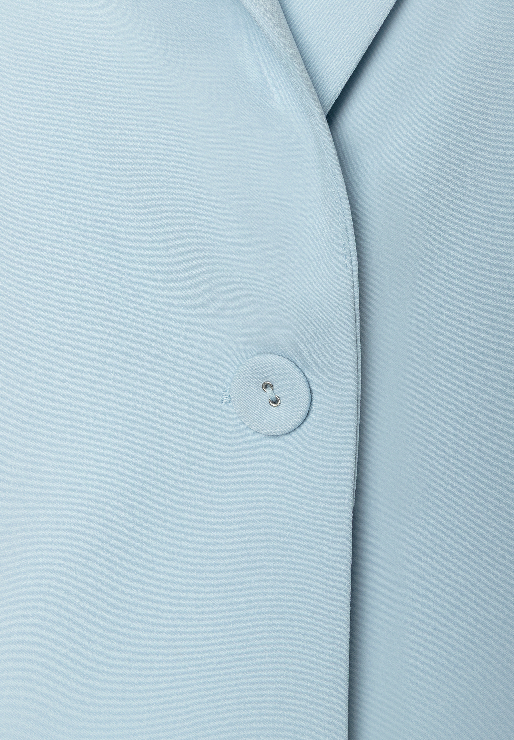 Detailansicht eines hellblauen MORE & MORE Blazers mit Knopf und Webware. Detailansicht eines hellblauen MORE & MORE Blazers mit Knopf und Webware.