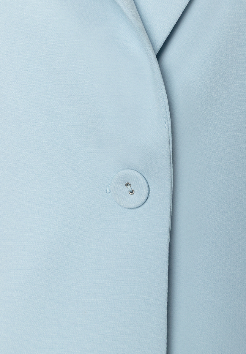 Detailansicht eines hellblauen MORE & MORE Blazers mit Knopf und Webware. Detailansicht eines hellblauen MORE & MORE Blazers mit Knopf und Webware.