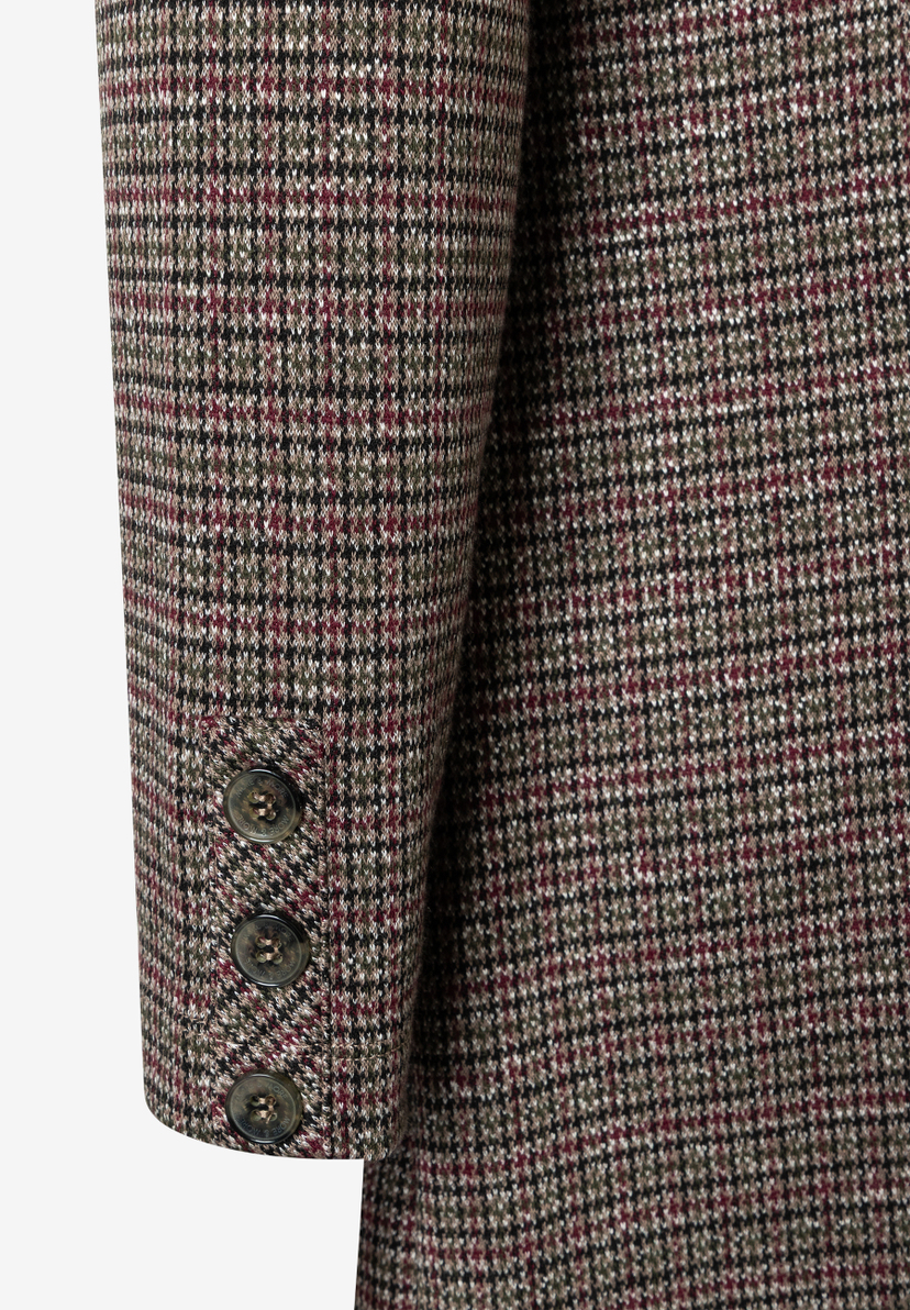 Nahaufnahme des Ärmels eines MORE & MORE Oberteils mit Hahnentrittmuster und drei Knöpfen. Nahaufnahme des Ärmels eines MORE & MORE Oberteils mit Hahnentrittmuster und drei Knöpfen.