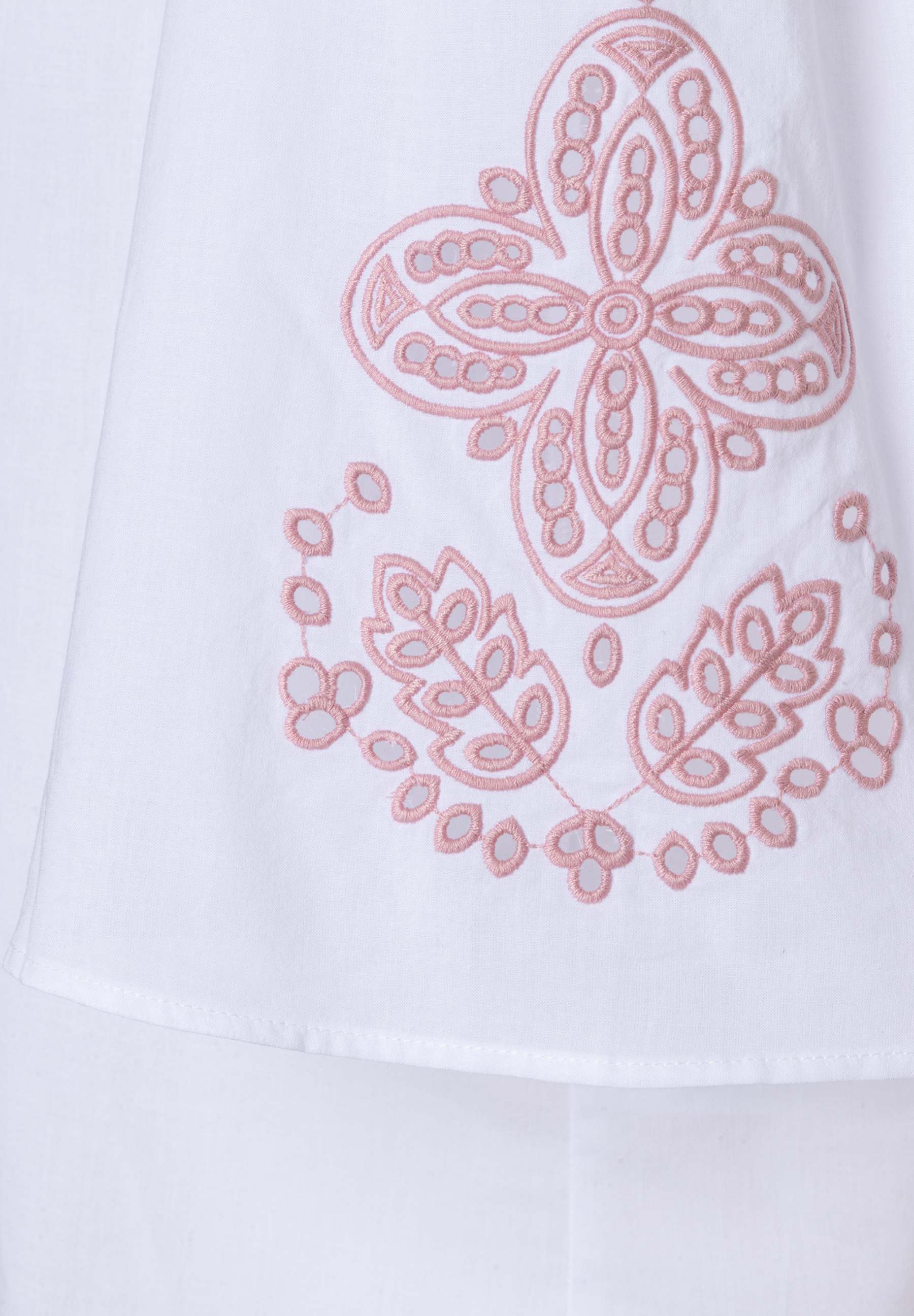 Detail einer weißen MORE & MORE Bluse mit rosa floraler Stickerei. Detail einer weißen MORE & MORE Bluse mit rosa floraler Stickerei.