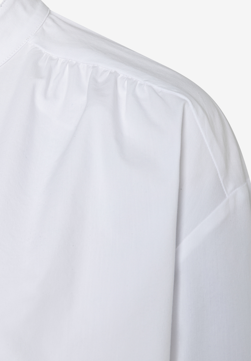 Detailaufnahme einer weißen MORE & MORE Bluse mit Popeline-Struktur, die angenehm, elastisch und hautfreundlich ist. Detailaufnahme einer weißen MORE & MORE Bluse mit Popeline-Struktur, die angenehm, elastisch und hautfreundlich ist.