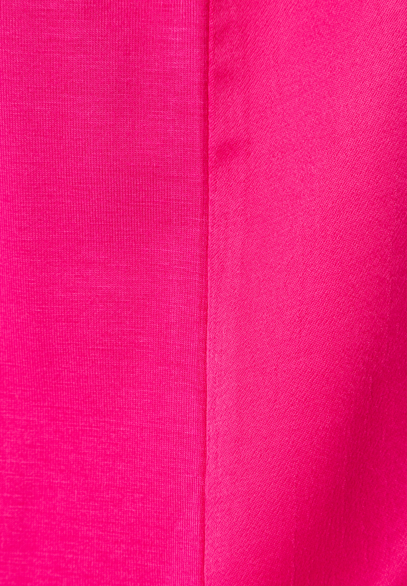 Nahaufnahme eines pinken MORE & MORE T-Shirts/Tops, das eine markante Textur zeigt. Nahaufnahme eines pinken MORE & MORE T-Shirts/Tops, das eine markante Textur zeigt.