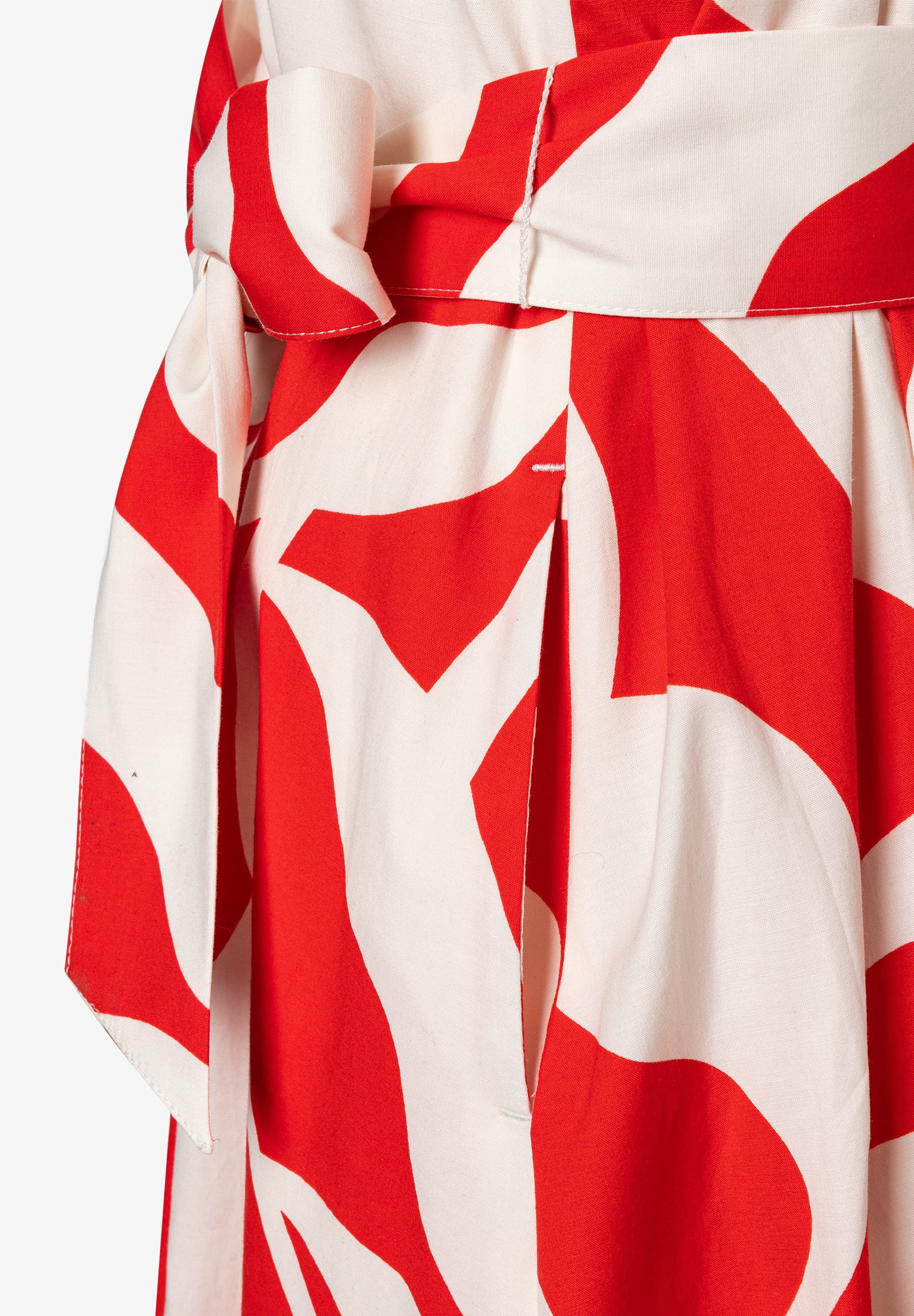 Nahaufnahme eines rot-weiß gemusterten MORE & MORE Oberteils mit Bindegürtel. Nahaufnahme eines rot-weiß gemusterten MORE & MORE Oberteils mit Bindegürtel.