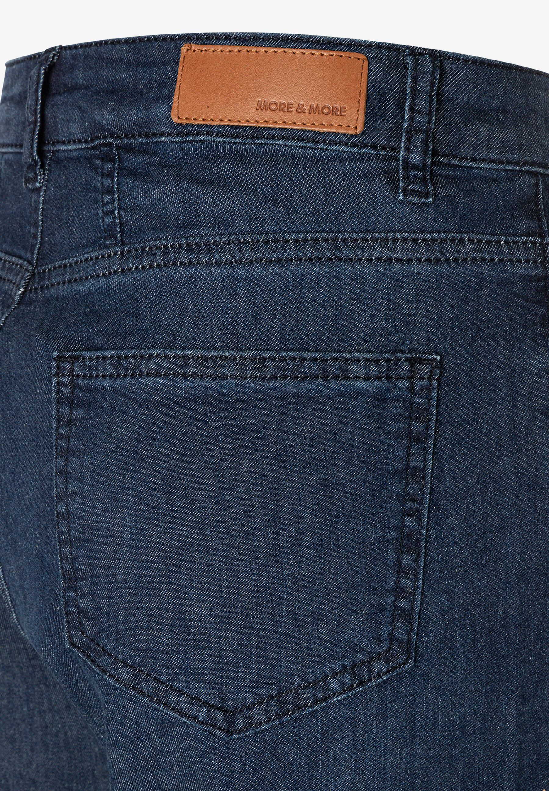 MORE & MORE Jeans: Nahaufnahme der Rückseite einer dunklen Jeans mit Lederetikett, Gesäßtasche und Gürtelschlaufen.