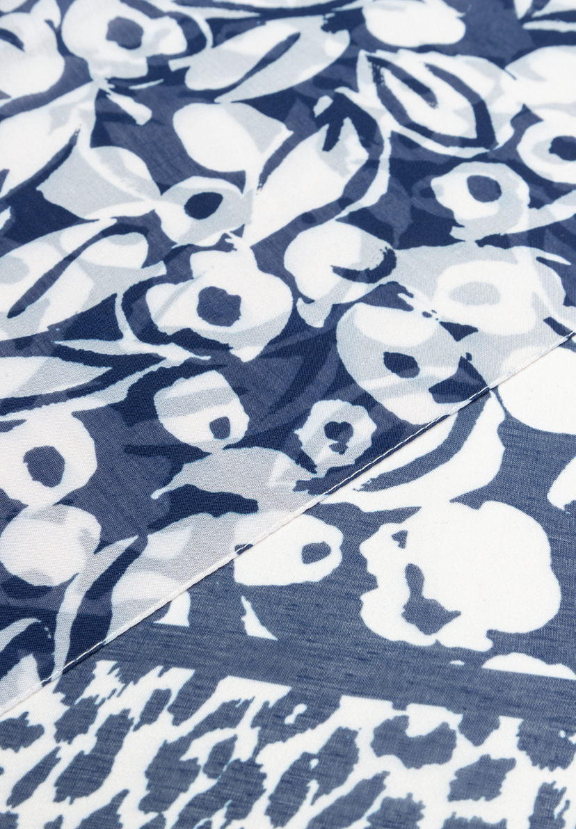 Nahaufnahme eines MORE & MORE Accessoires mit blau-weißem Blumenmuster und einer Naht. Nahaufnahme eines MORE & MORE Accessoires mit blau-weißem Blumenmuster und einer Naht.