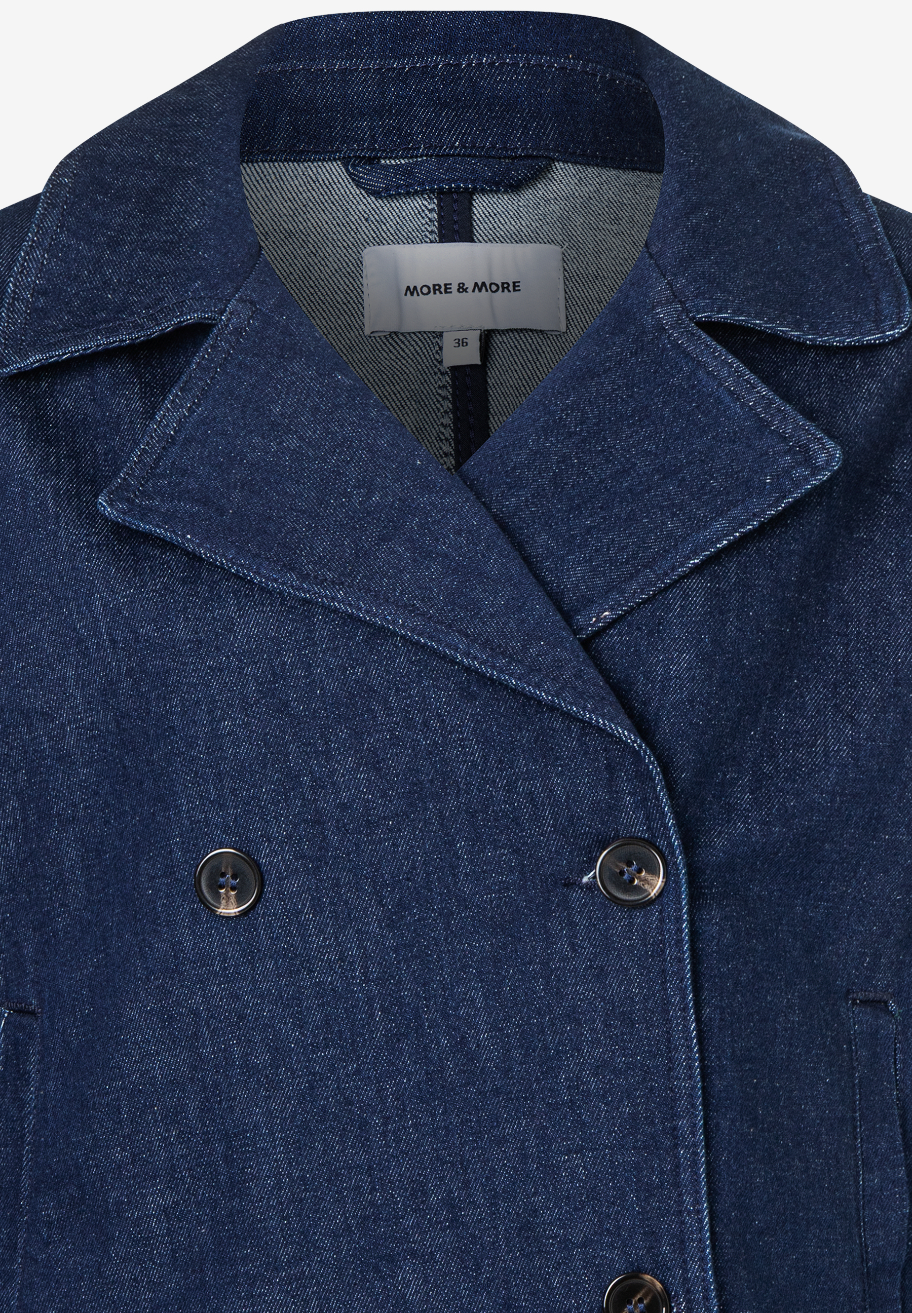 Nahaufnahme einer blauen Jeansjacke von MORE & MORE mit doppelreihiger Knopfleiste und Reverskragen. Nahaufnahme einer blauen Jeansjacke von MORE & MORE mit doppelreihiger Knopfleiste und Reverskragen.