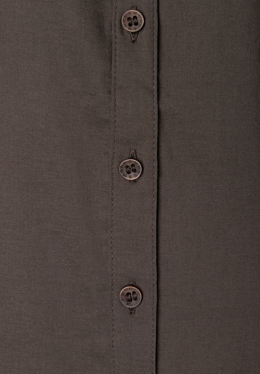 MORE & MORE Popeline-Bluse aus Baumwollmischung. Nahaufnahme der Knopfleiste mit dunkelbraunen Knöpfen mit Logo-Prägung. MORE & MORE Popeline-Bluse aus Baumwollmischung. Nahaufnahme der Knopfleiste mit dunkelbraunen Knöpfen mit Logo-Prägung.
