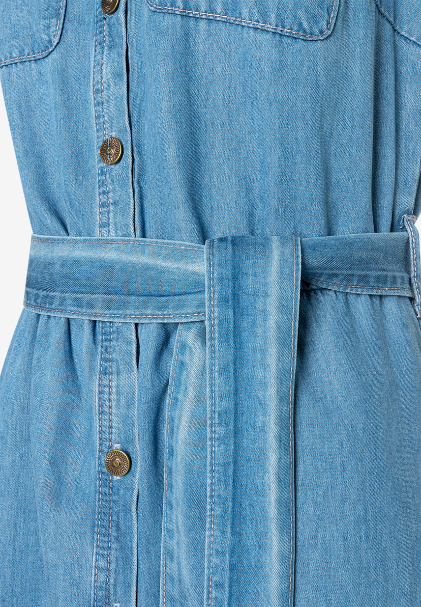 Nahaufnahme eines MORE & MORE Oberteils aus Denim mit Gürtel und Knöpfen. Nahaufnahme eines MORE & MORE Oberteils aus Denim mit Gürtel und Knöpfen.