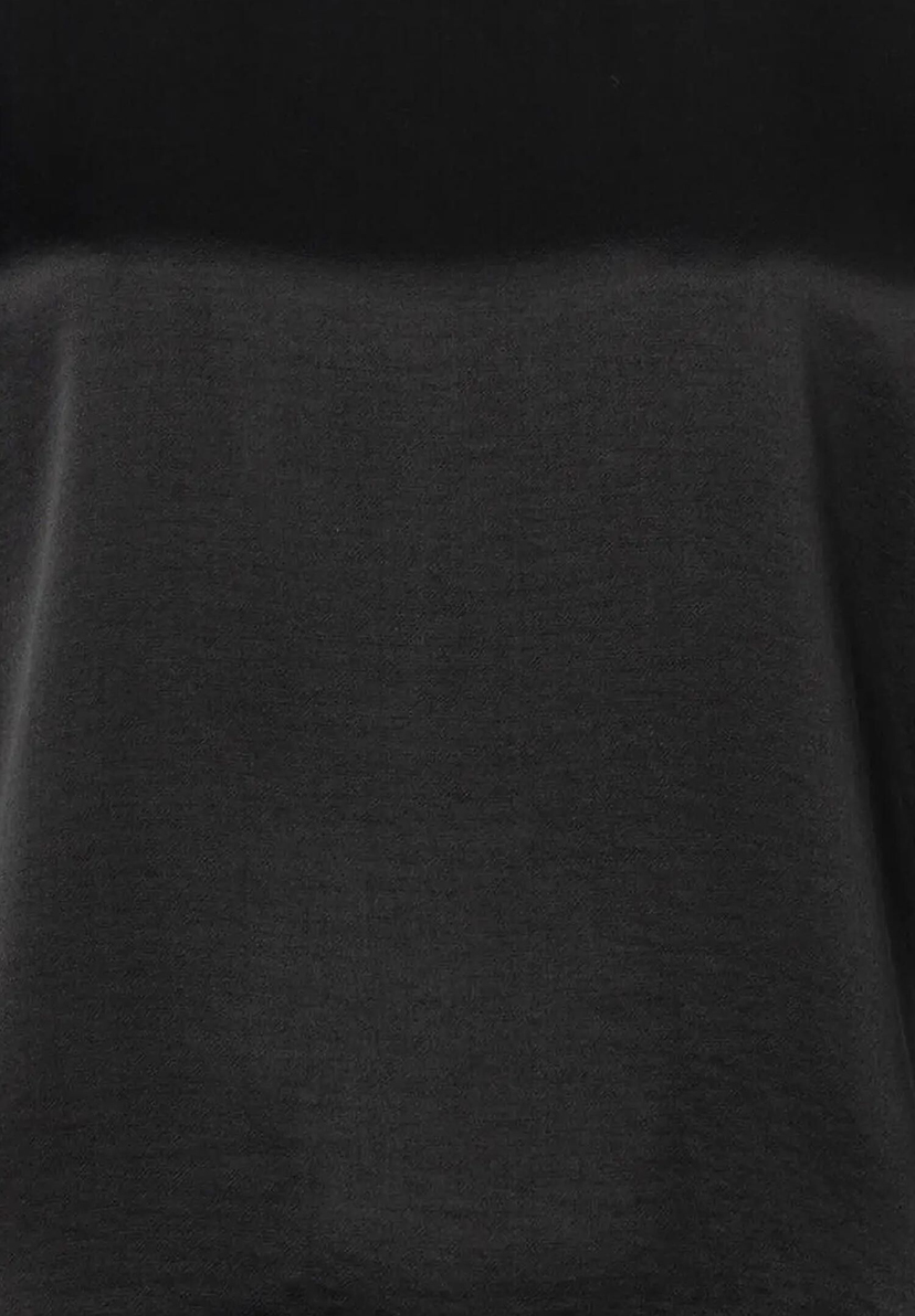 Detailaufnahme eines schwarzen MORE & MORE Oberteils aus Jersey und Satin mit seidigem Glanz. Detailaufnahme eines schwarzen MORE & MORE Oberteils aus Jersey und Satin mit seidigem Glanz.