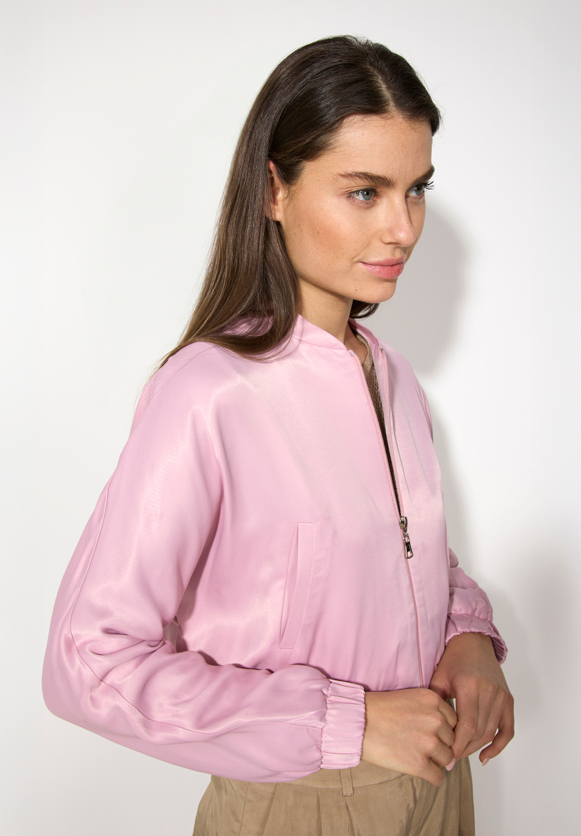 Eine Frau mit einem MORE & MORE Blazer mit glänzender Optik aus Satin.