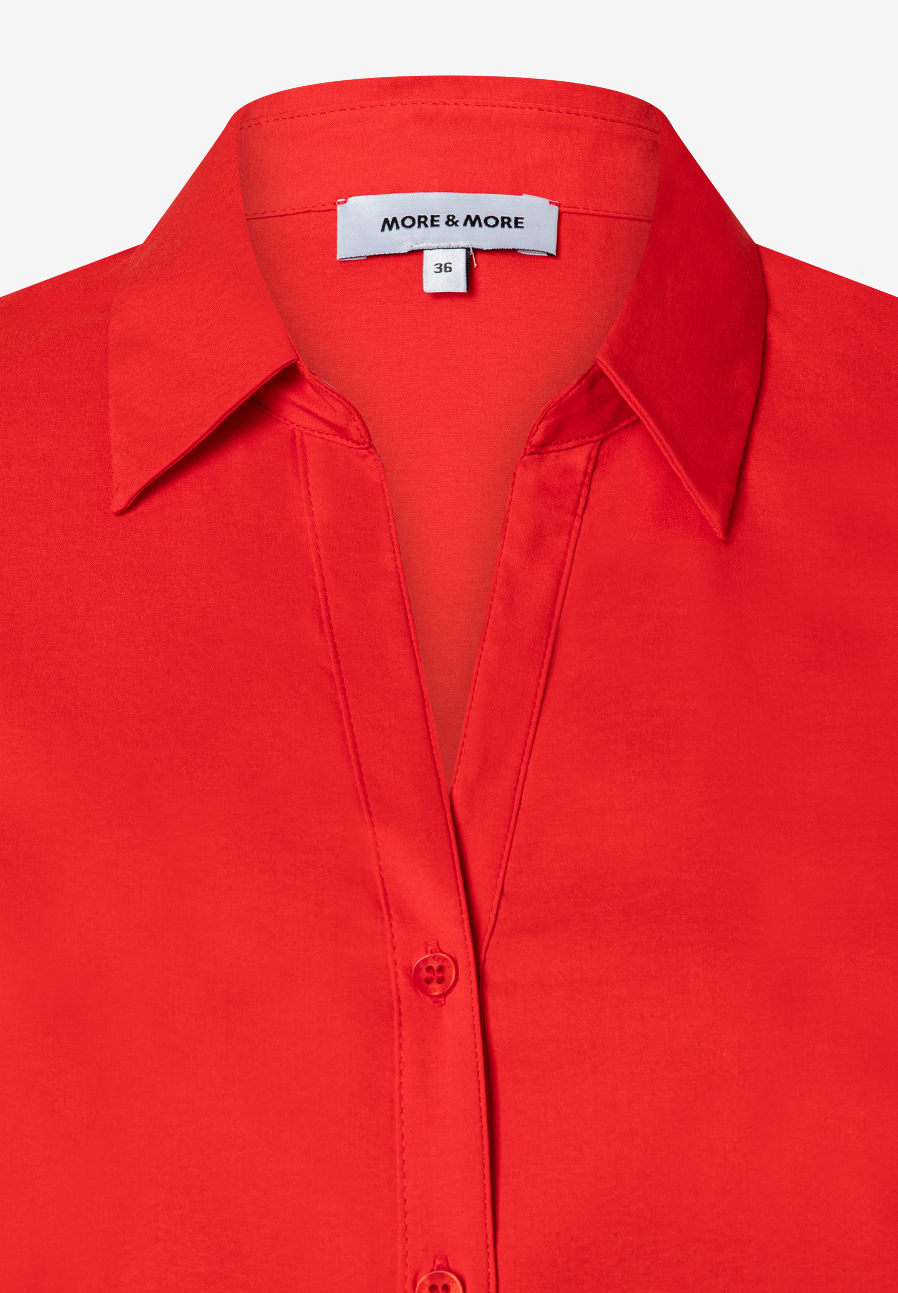 Nahaufnahme einer roten MORE & MORE Bluse aus Popeline mit Knopfleiste und Kragen. Nahaufnahme einer roten MORE & MORE Bluse aus Popeline mit Knopfleiste und Kragen.