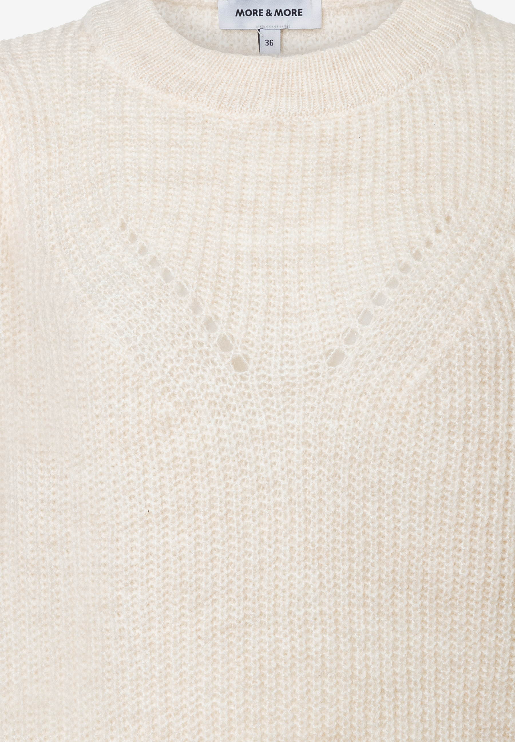 Nahaufnahme eines weißen MORE & MORE Strickpullovers mit rundem Halsausschnitt und Lochmuster. Nahaufnahme eines weißen MORE & MORE Strickpullovers mit rundem Halsausschnitt und Lochmuster.