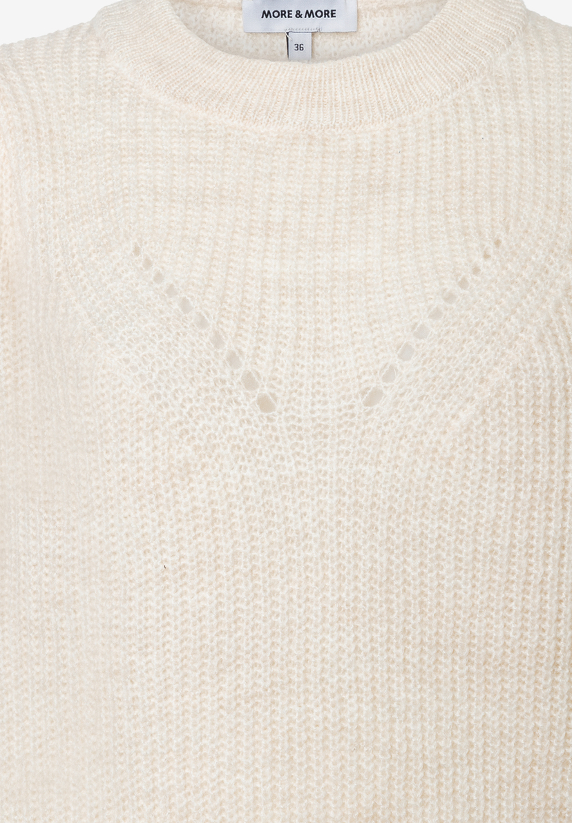 Nahaufnahme eines weißen MORE & MORE Strickpullovers mit rundem Halsausschnitt und Lochmuster. Nahaufnahme eines weißen MORE & MORE Strickpullovers mit rundem Halsausschnitt und Lochmuster.