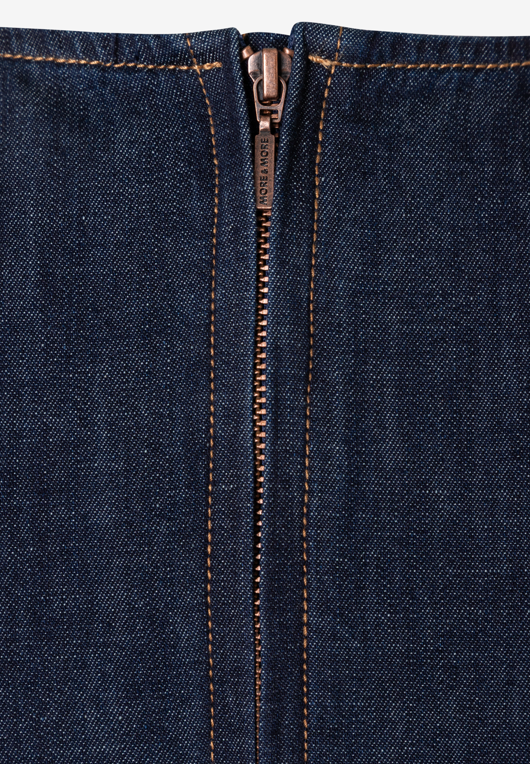 Nahaufnahme eines MORE & MORE-Oberteils aus Denim mit Reißverschluss. Nahaufnahme eines MORE & MORE-Oberteils aus Denim mit Reißverschluss.