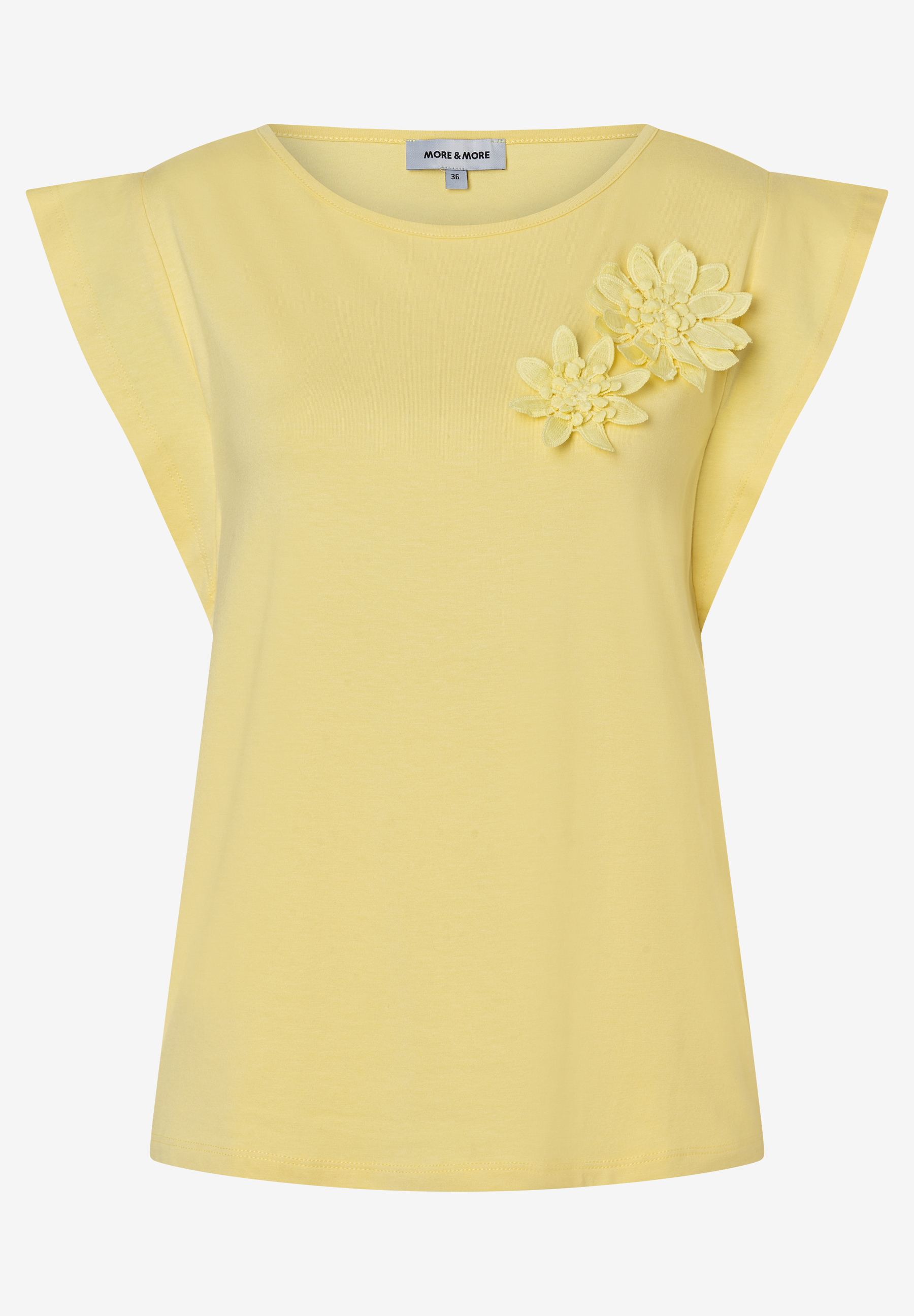Ein gelbes MORE & MORE Top mit Blütenapplikationen auf der rechten Brust.