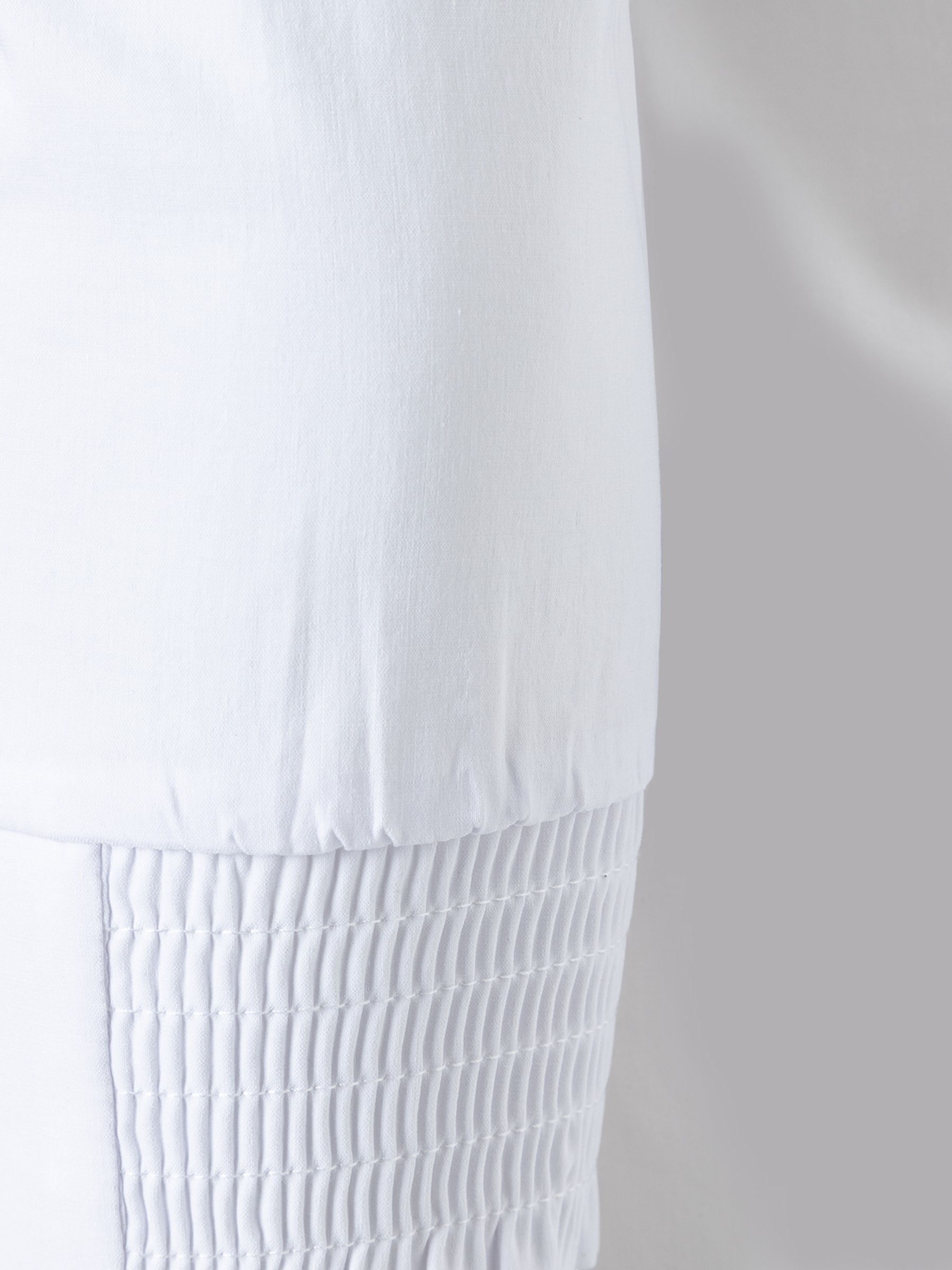 Detailansicht einer weißen MORE & MORE Bluse aus Baumwollmischung mit Stretch-Anteil und Raffungen. Detailansicht einer weißen MORE & MORE Bluse aus Baumwollmischung mit Stretch-Anteil und Raffungen.