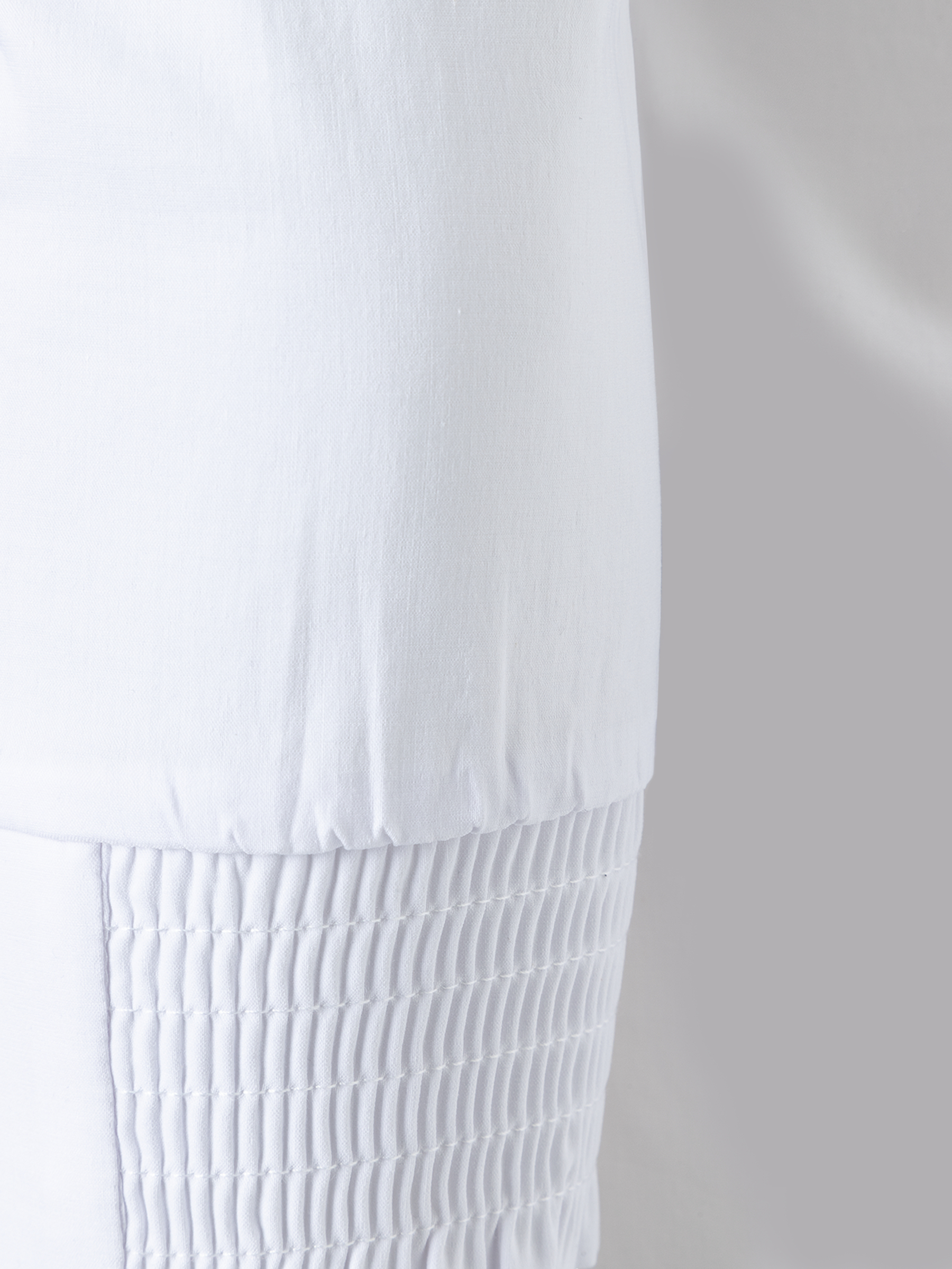 Detailansicht einer weißen MORE & MORE Bluse aus Baumwollmischung mit Stretch-Anteil und Raffungen. Detailansicht einer weißen MORE & MORE Bluse aus Baumwollmischung mit Stretch-Anteil und Raffungen.