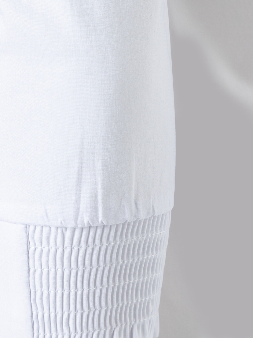 Detailansicht einer weißen MORE & MORE Bluse aus Baumwollmischung mit Stretch-Anteil und Raffungen. Detailansicht einer weißen MORE & MORE Bluse aus Baumwollmischung mit Stretch-Anteil und Raffungen.
