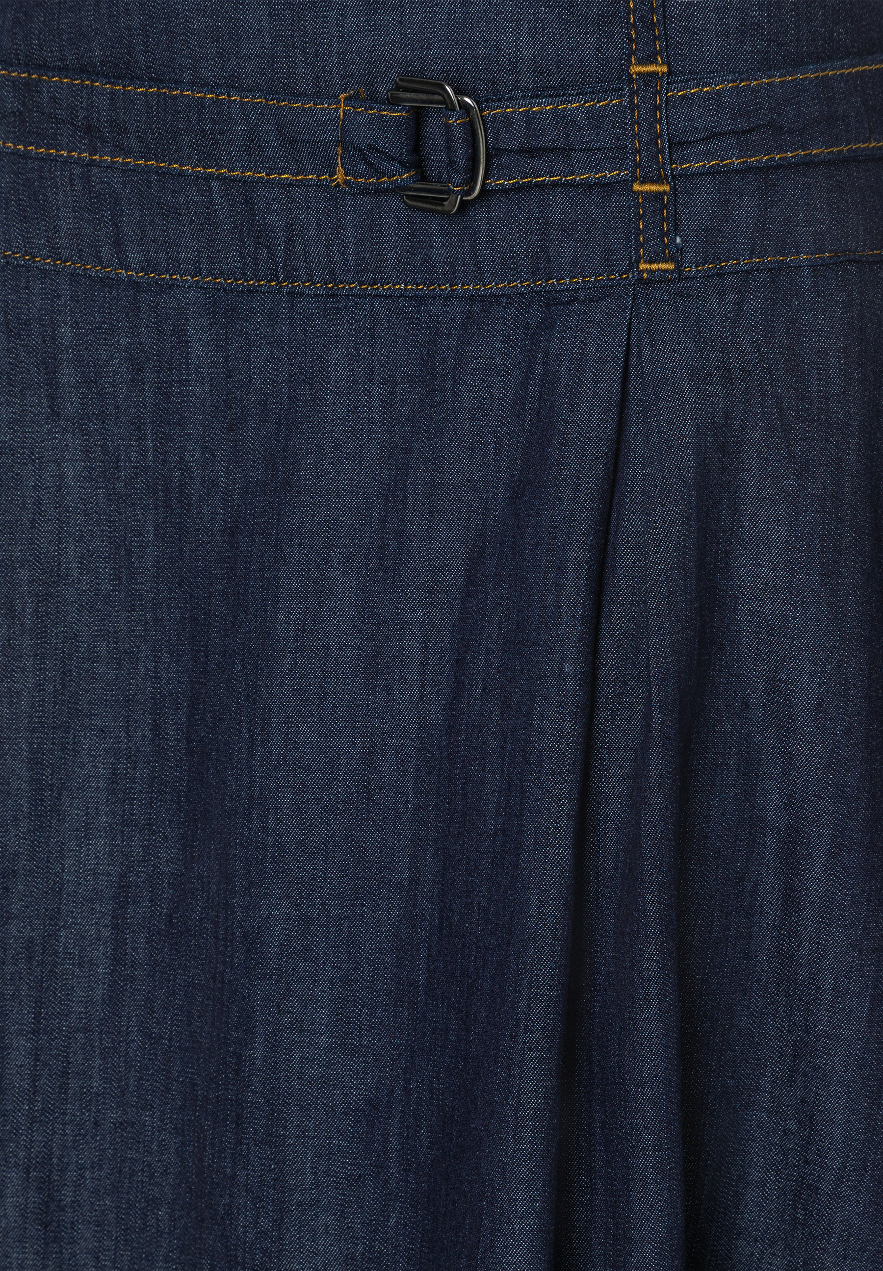 Nahaufnahme eines MORE & MORE Jeansrocks mit Gürtelschnalle und gelben Nähten. Nahaufnahme eines MORE & MORE Jeansrocks mit Gürtelschnalle und gelben Nähten.