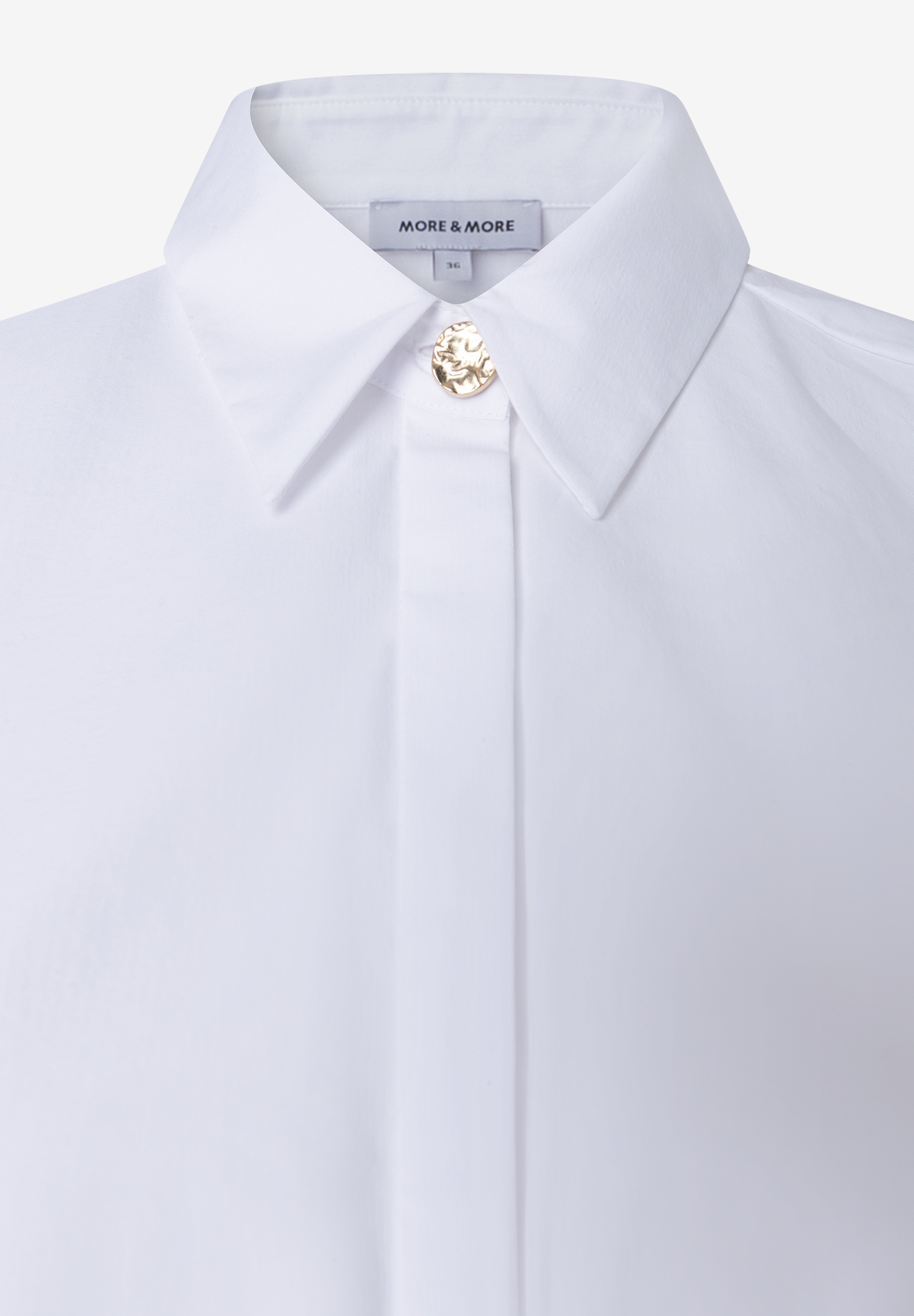 MORE & MORE weiße Bluse. Detailaufnahme zeigt goldenen, runden Knopfverschluss, der wie gehämmert aussieht. MORE & MORE weiße Bluse. Detailaufnahme zeigt goldenen, runden Knopfverschluss, der wie gehämmert aussieht.