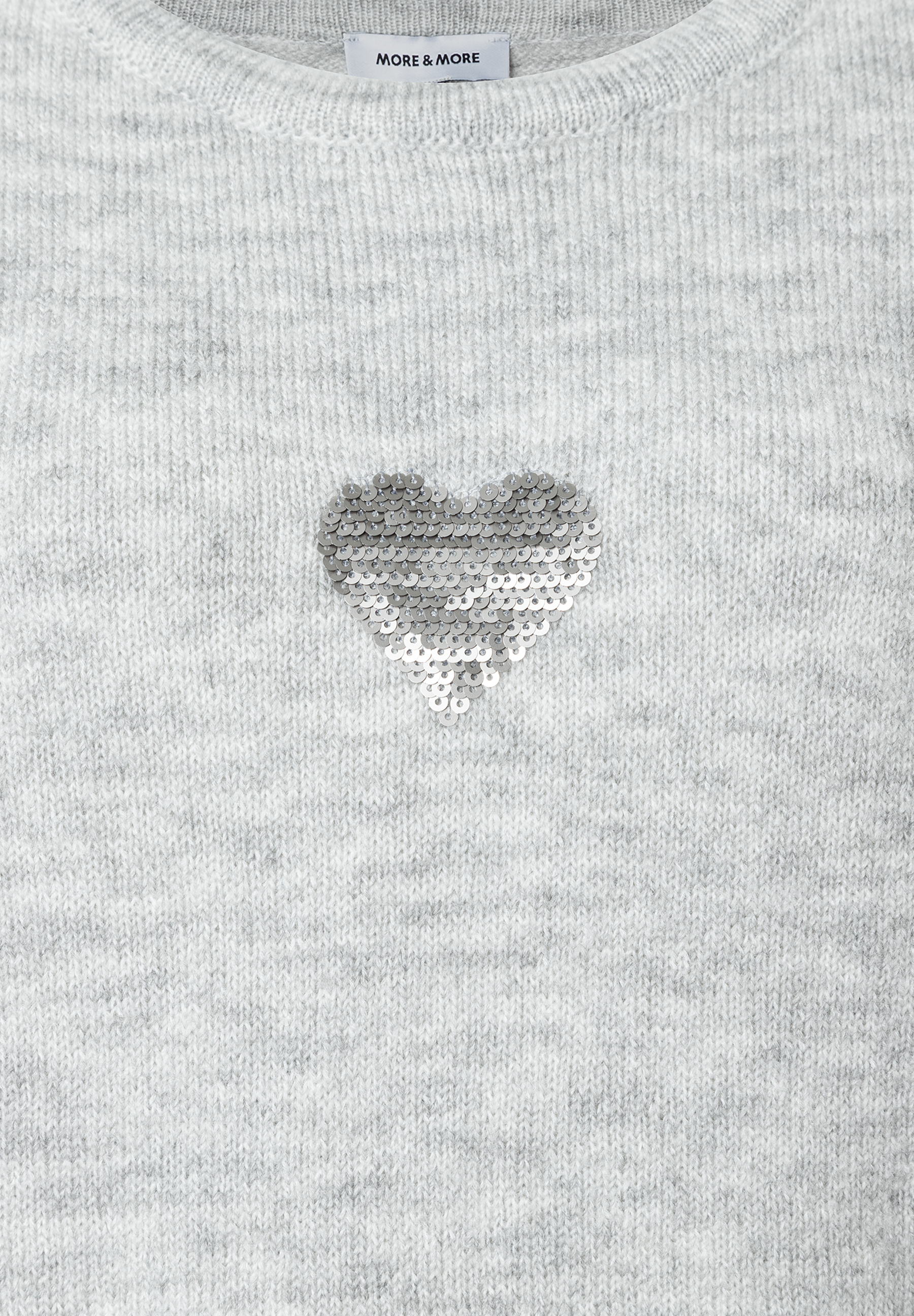Grauer Feinstrick-Pullover von MORE & MORE mit einem glitzernden Herz aus Pailletten. Grauer Feinstrick-Pullover von MORE & MORE mit einem glitzernden Herz aus Pailletten.