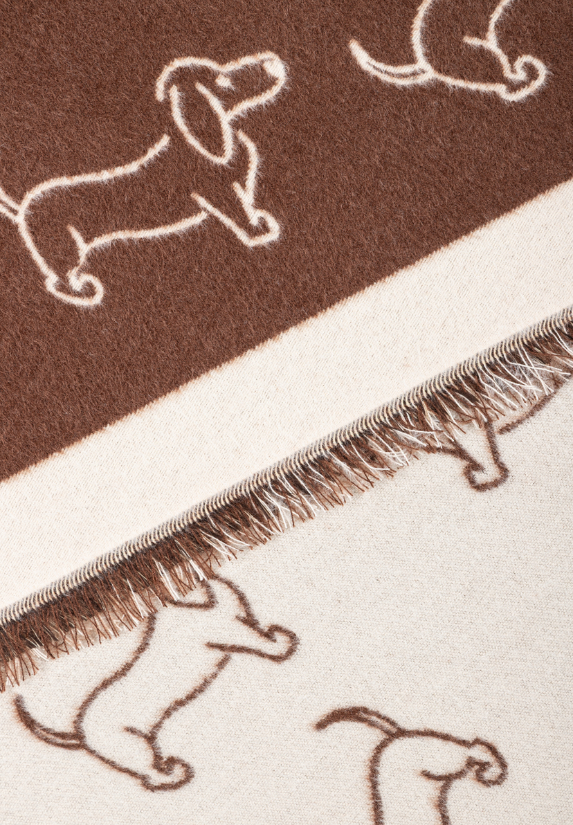 MORE & MORE Accessoire: Braune Decke mit Fransensaum & Dackel-Muster in Creme. Blick auf Muster & Textur.