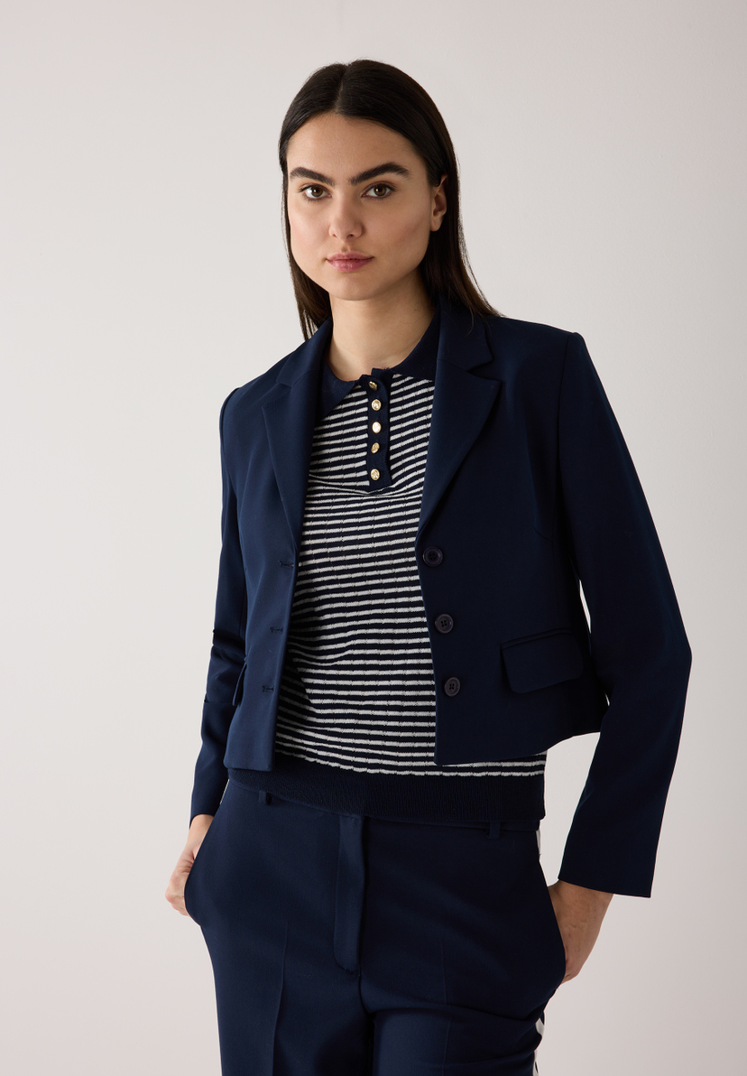 Eine Frau mit einem MORE & MORE Blazer und einer passenden Hose. Eine Frau mit einem MORE & MORE Blazer und einer passenden Hose.