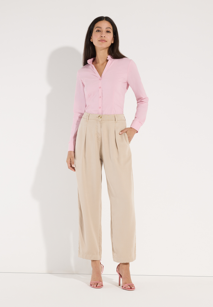 MORE & MORE Jeans: junge Frau mit lachsfarbener Hemdbluse u. beigefarbener Webware-Hose mit weitem Bein. Hände in Hosentaschen, dazu pinke Sandaletten. MORE & MORE Jeans: junge Frau mit lachsfarbener Hemdbluse u. beigefarbener Webware-Hose mit weitem Bein. Hände in Hosentaschen, dazu pinke Sandaletten.